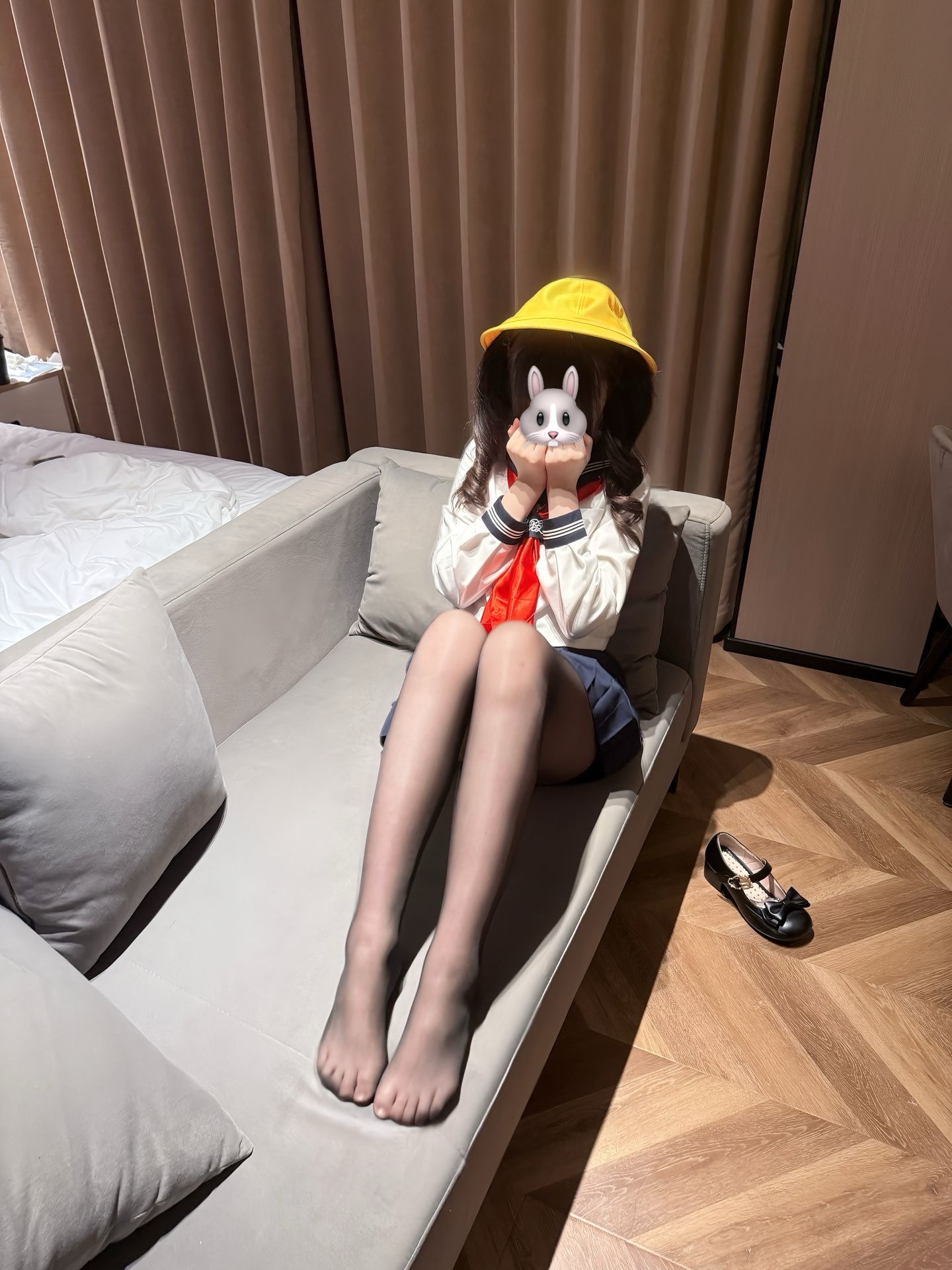 穿着黄色帽子和白色衬衫的女人坐在沙发上。