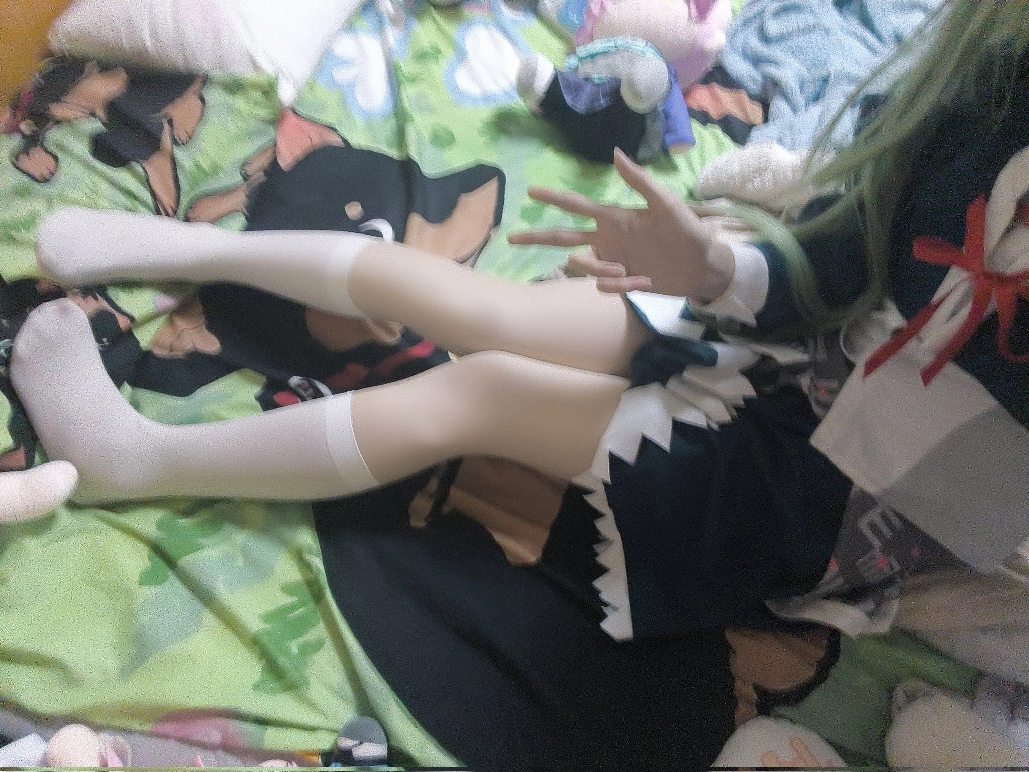 穿着绿色衣服的女孩坐在床上。