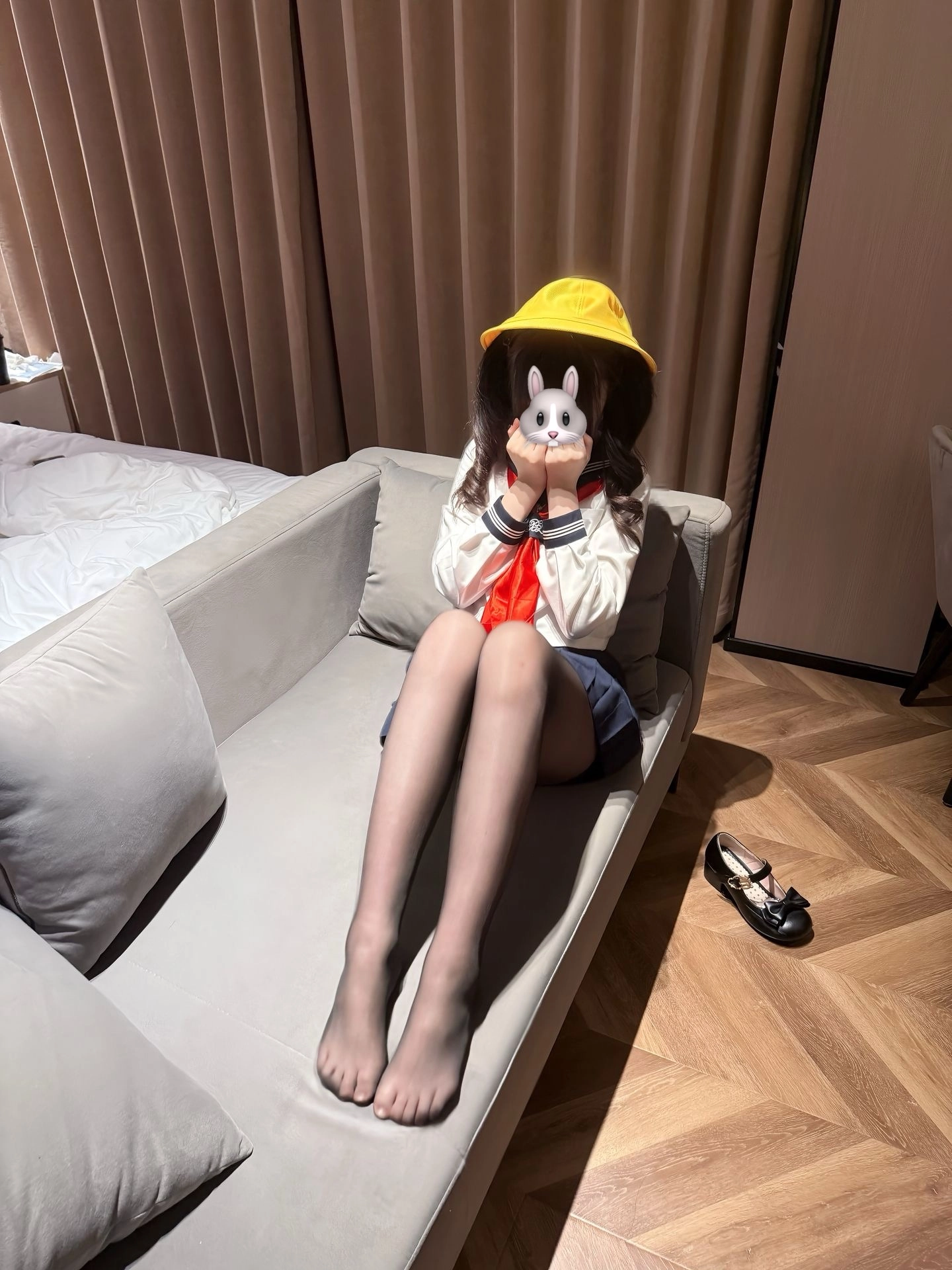 穿着黄色帽子和白色衬衫的女人坐在沙发上。