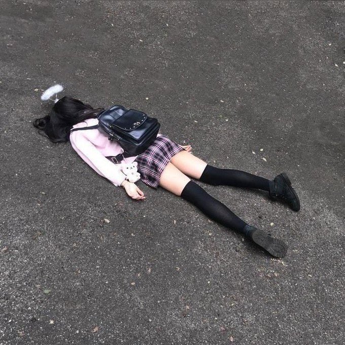 女孩躺在地上,背着背包。