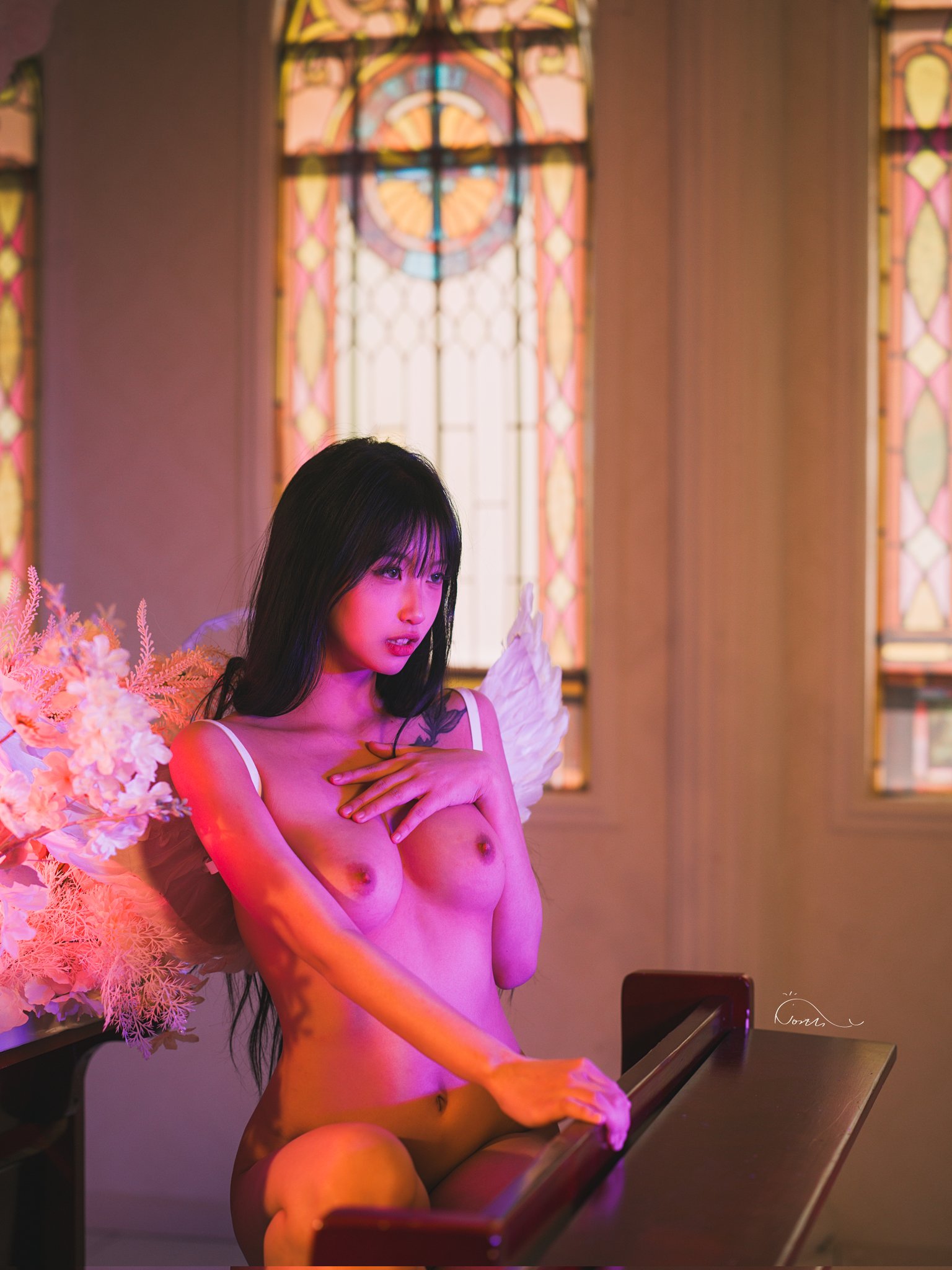 带着翅膀和粉红色的裙子的女人坐在钢琴上。