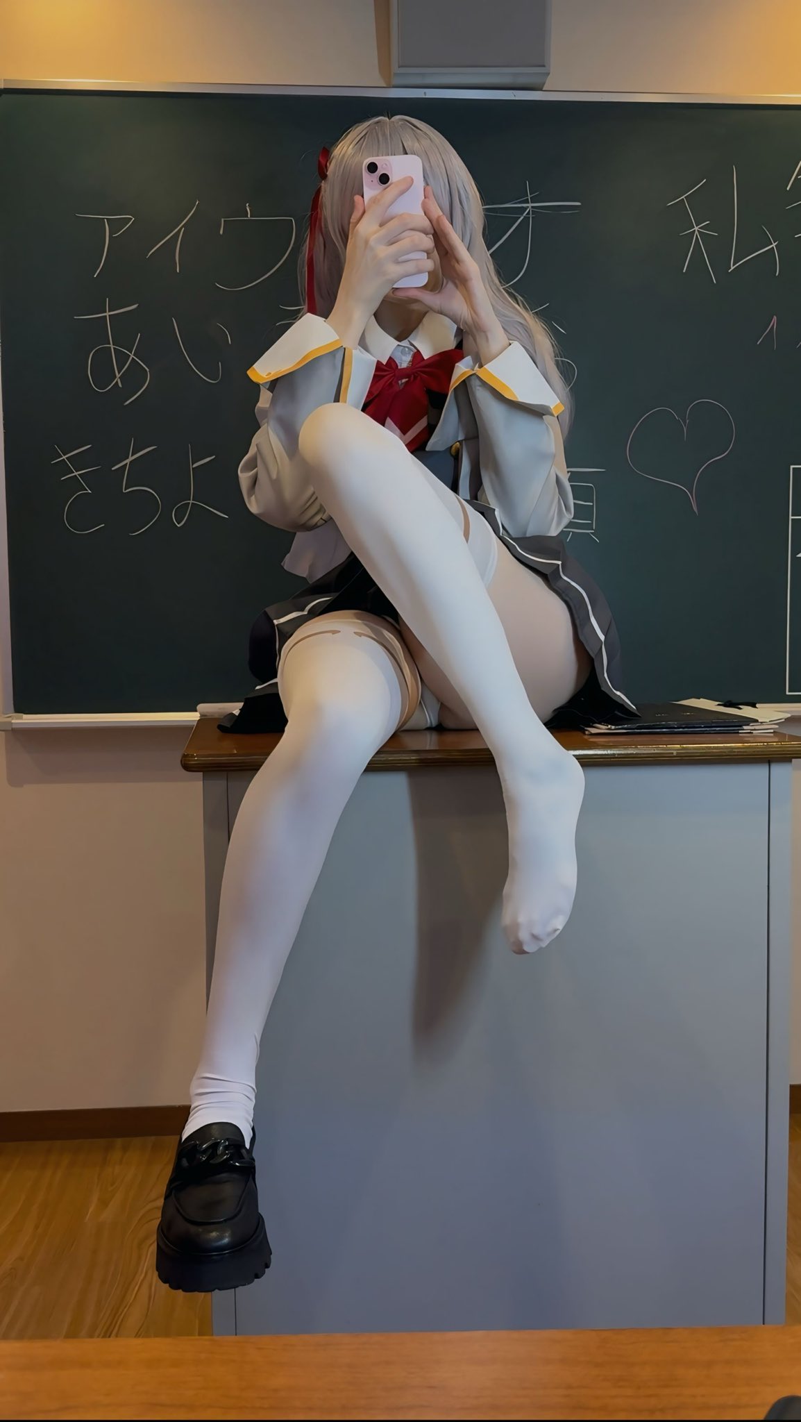 穿着校服的女人坐在一张桌子上。