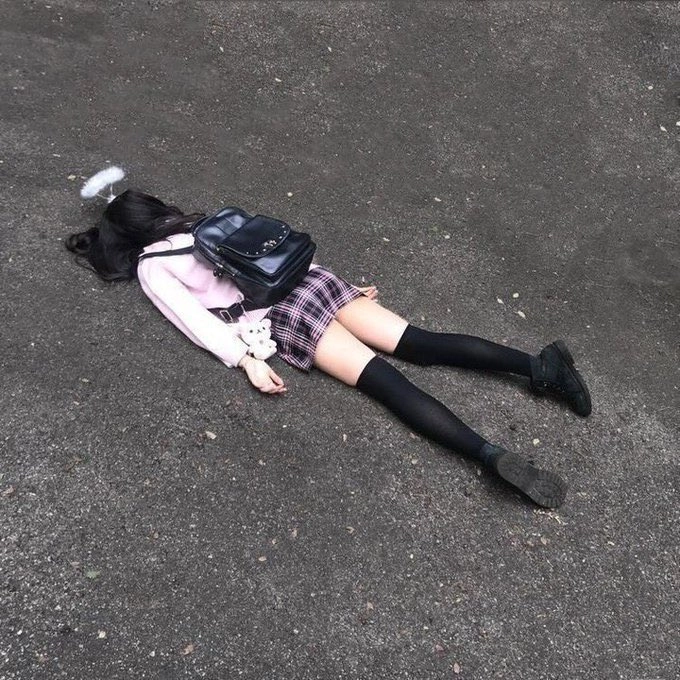 女孩躺在地上,背着背包。