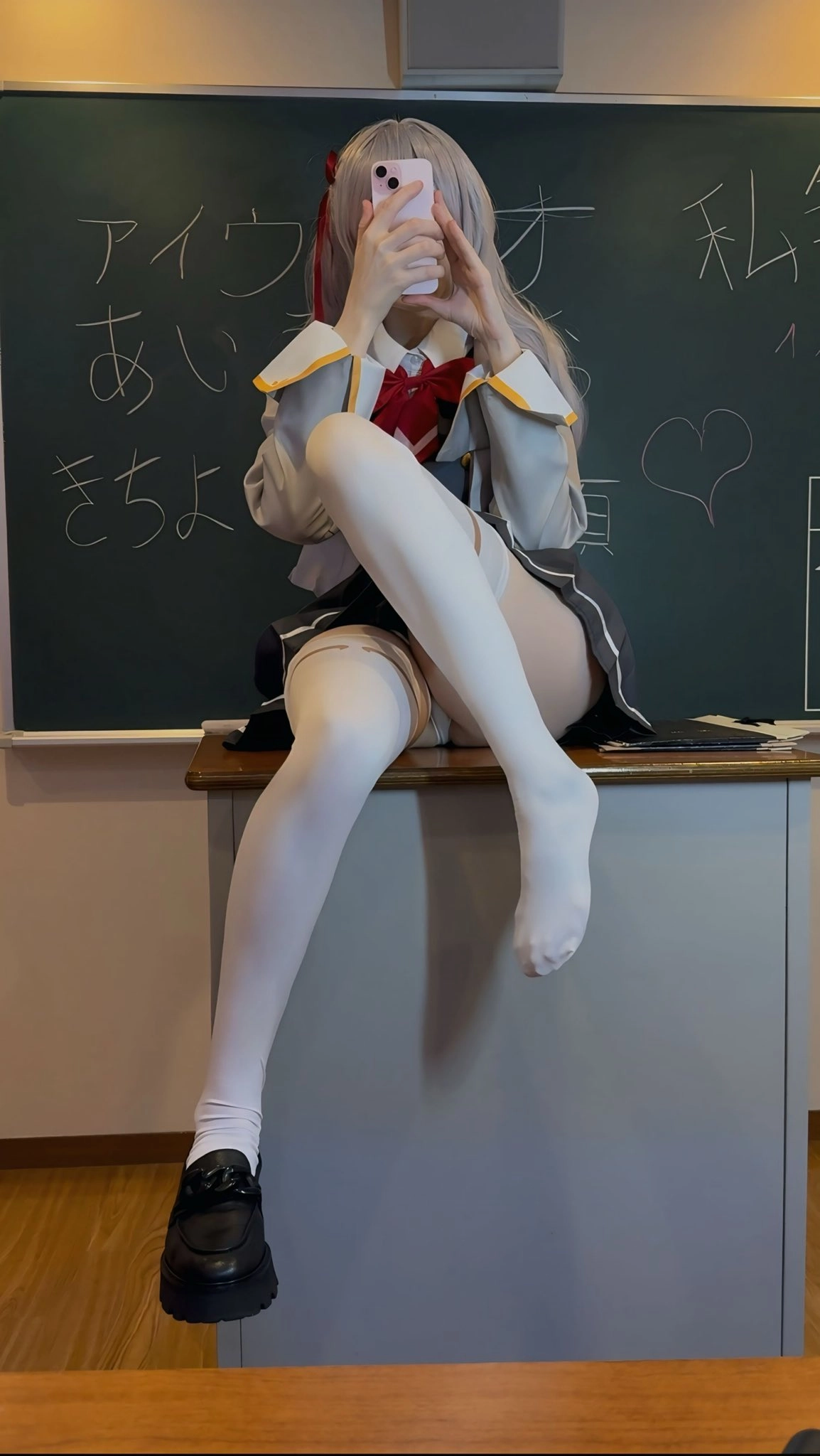 穿着校服的女人坐在一张桌子上。