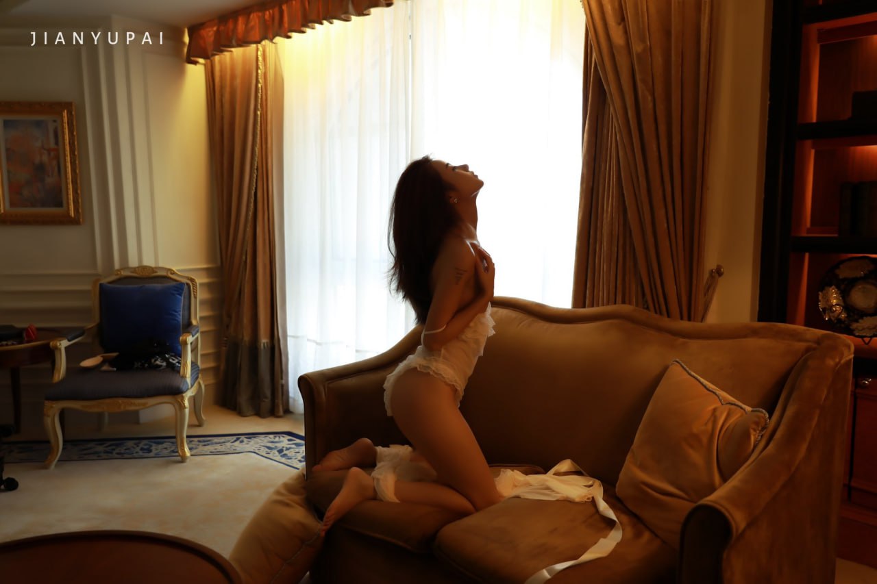 穿着白色裙子的女人坐在沙发上。