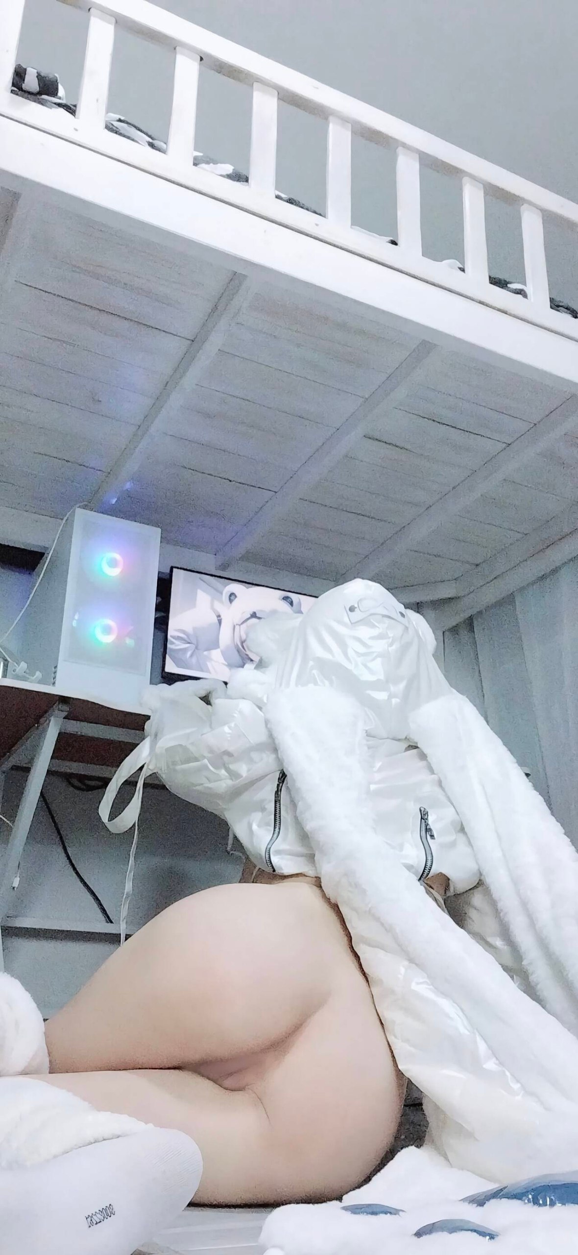 一位穿着白色衣服的女人站在电视机前。