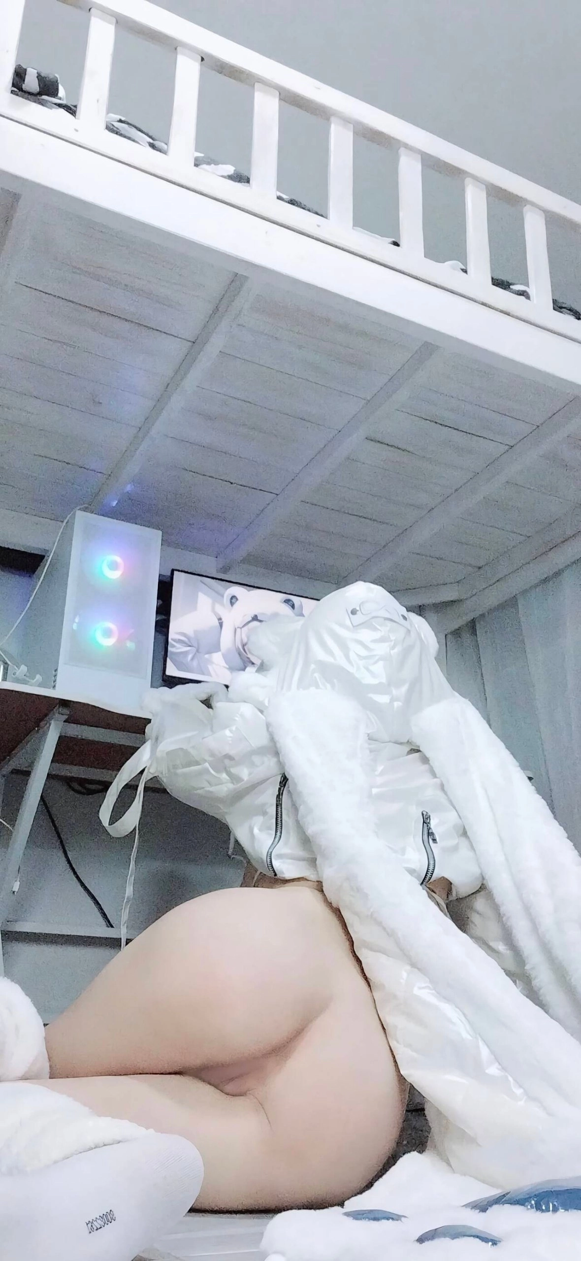 一位穿着白色衣服的女人站在电视机前。