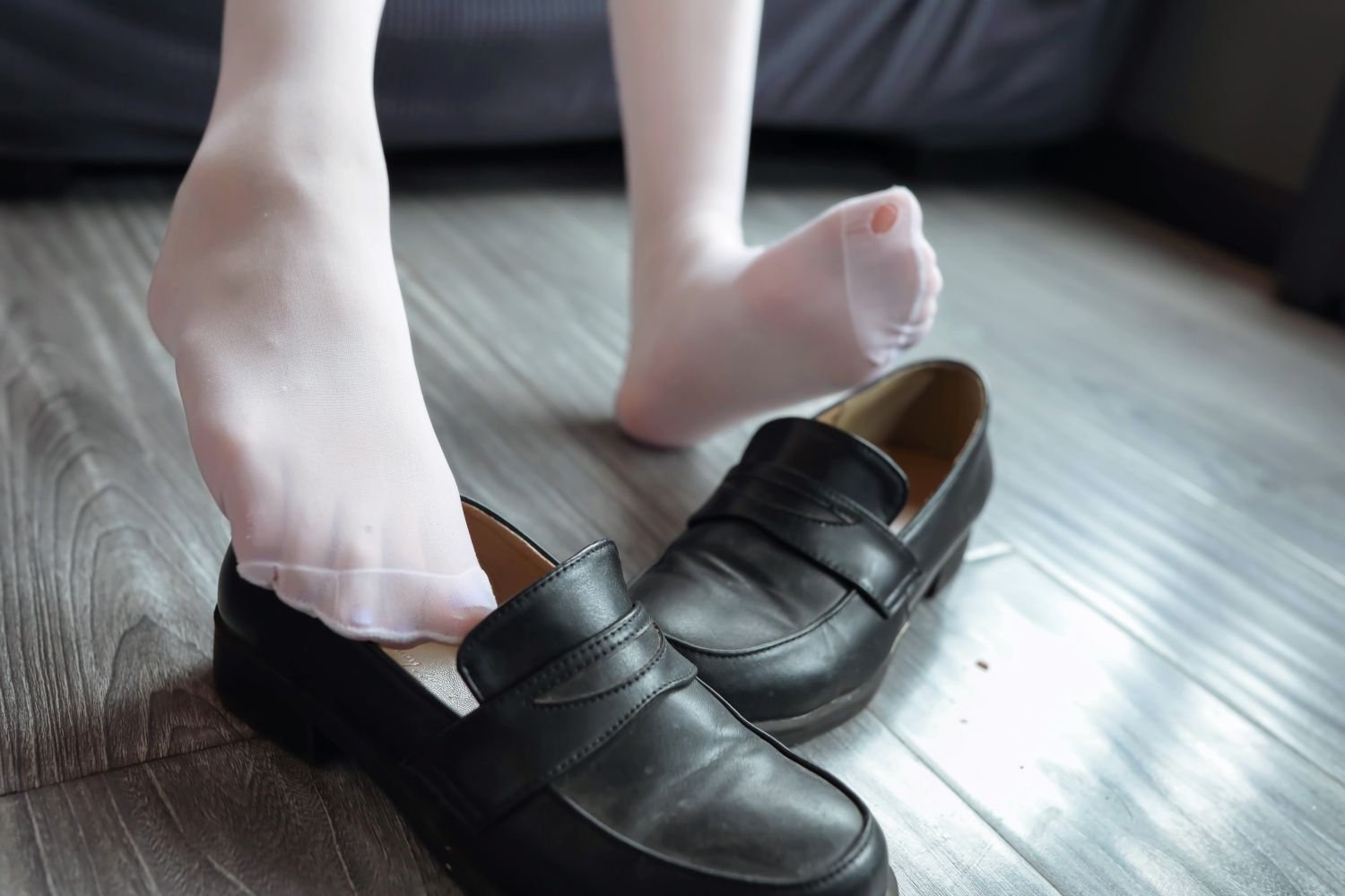 穿着白色衬衫和黑色衬衫的女人坐在沙发上。