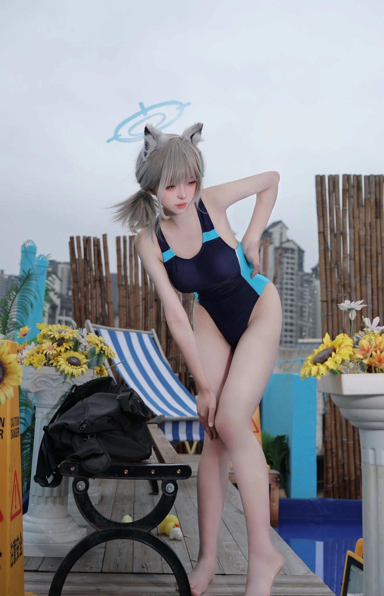 穿着蓝色和黑色比基尼的女人用一个袋子和一个椅子。