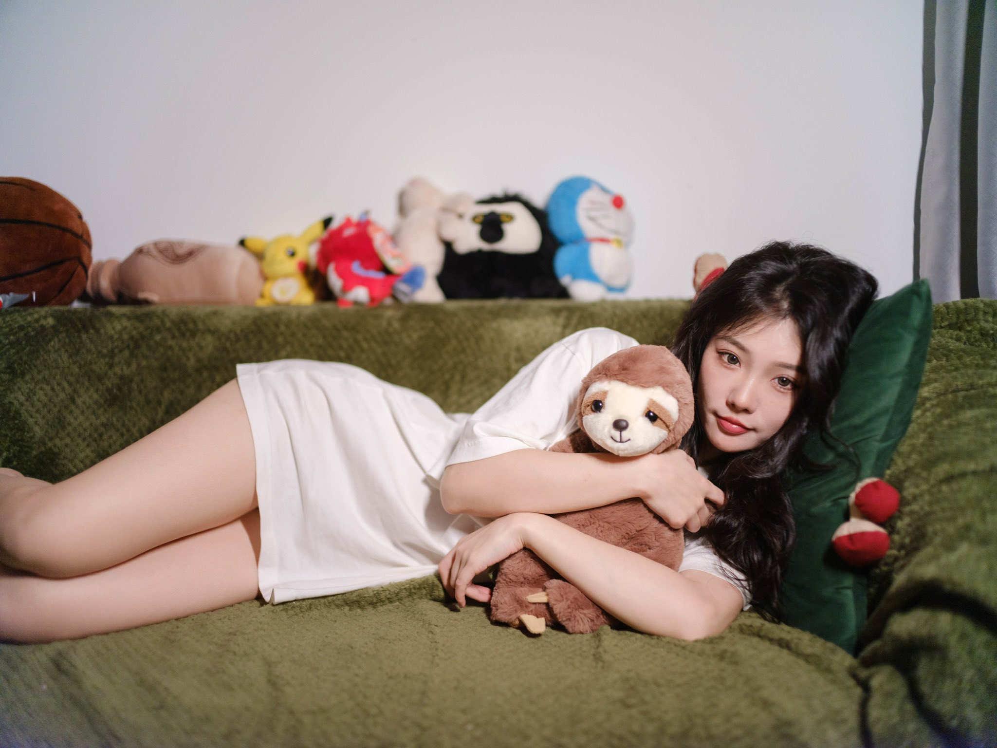 女孩躺在一张沙发上,带着一只被困的动物。