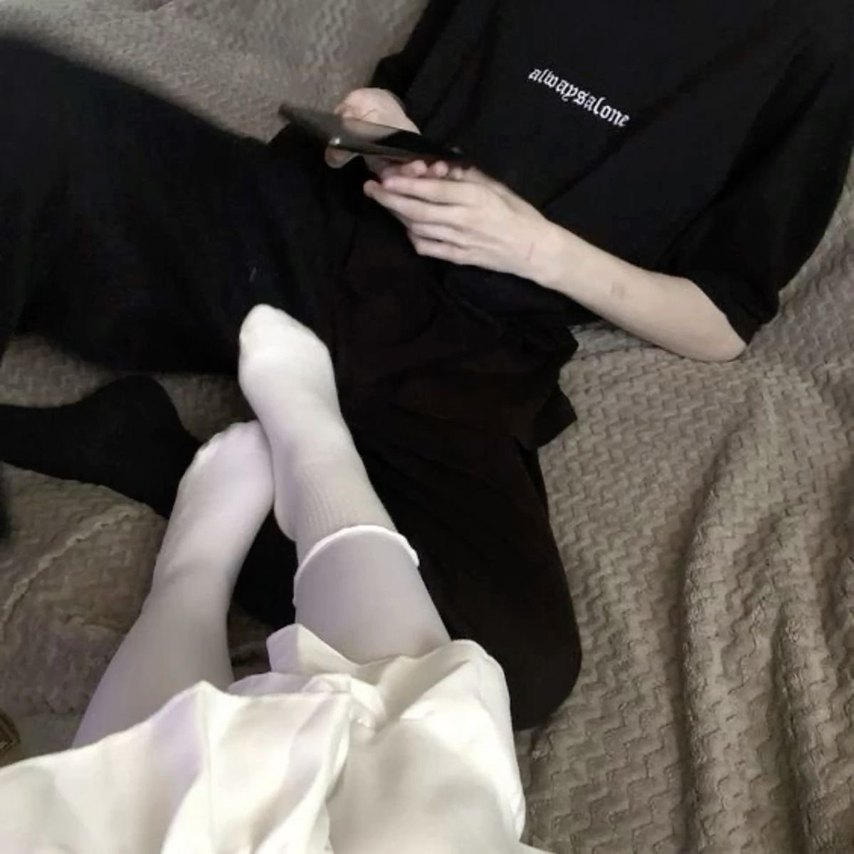 男人坐在床上,一个女人的脚在他的膝盖上。