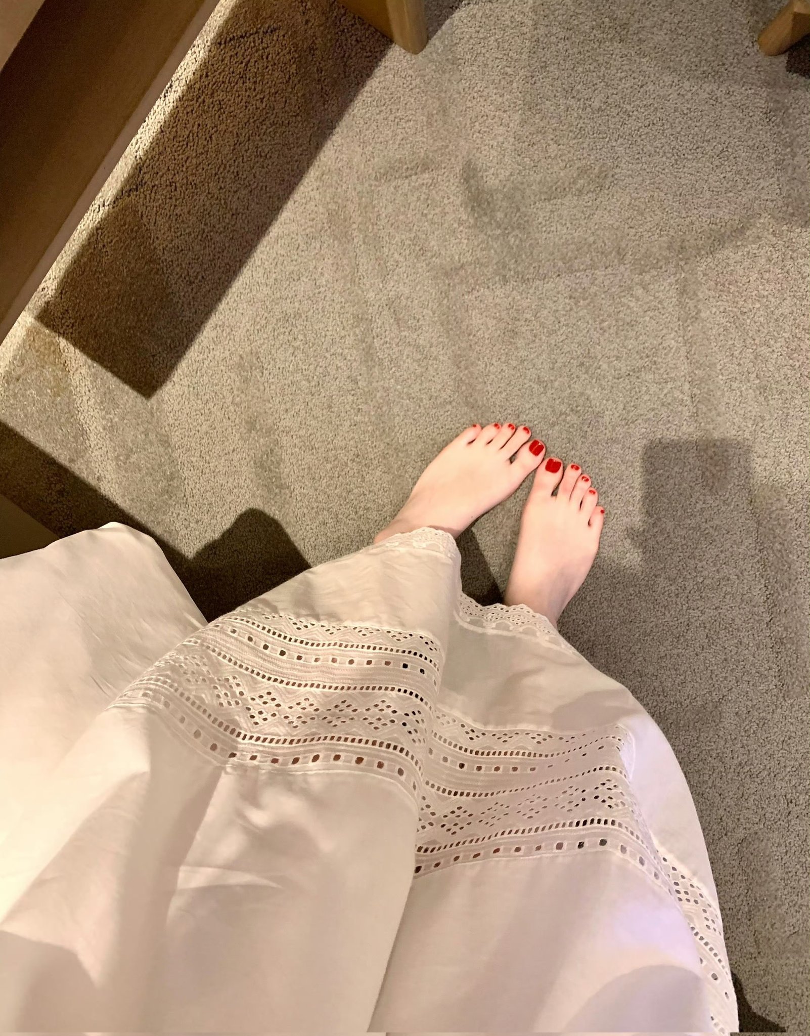 穿白衣的女人坐在地板上。