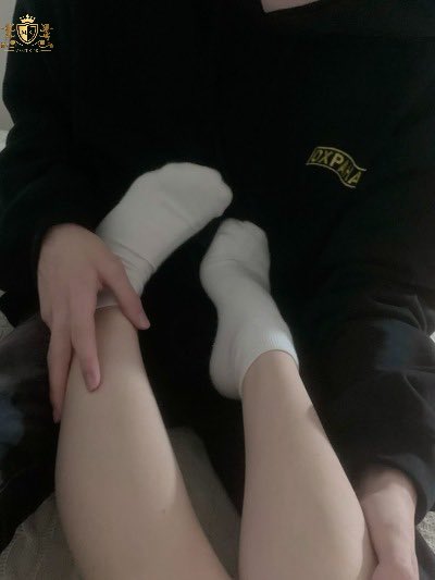 男人坐在床上,一个女人的脚在他的膝盖上。