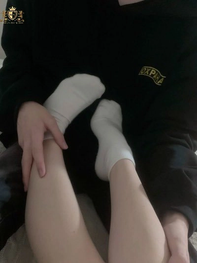 男人坐在床上,一个女人的脚在他的膝盖上。