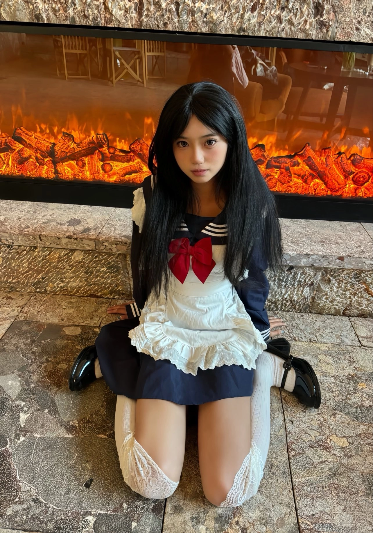 穿着水手服的女人坐在火炉前面。