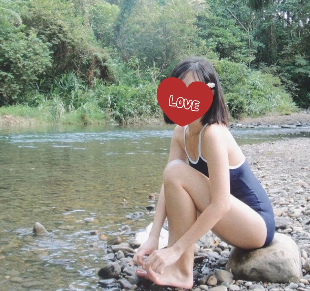 带着心在脸上坐在河边的女人。