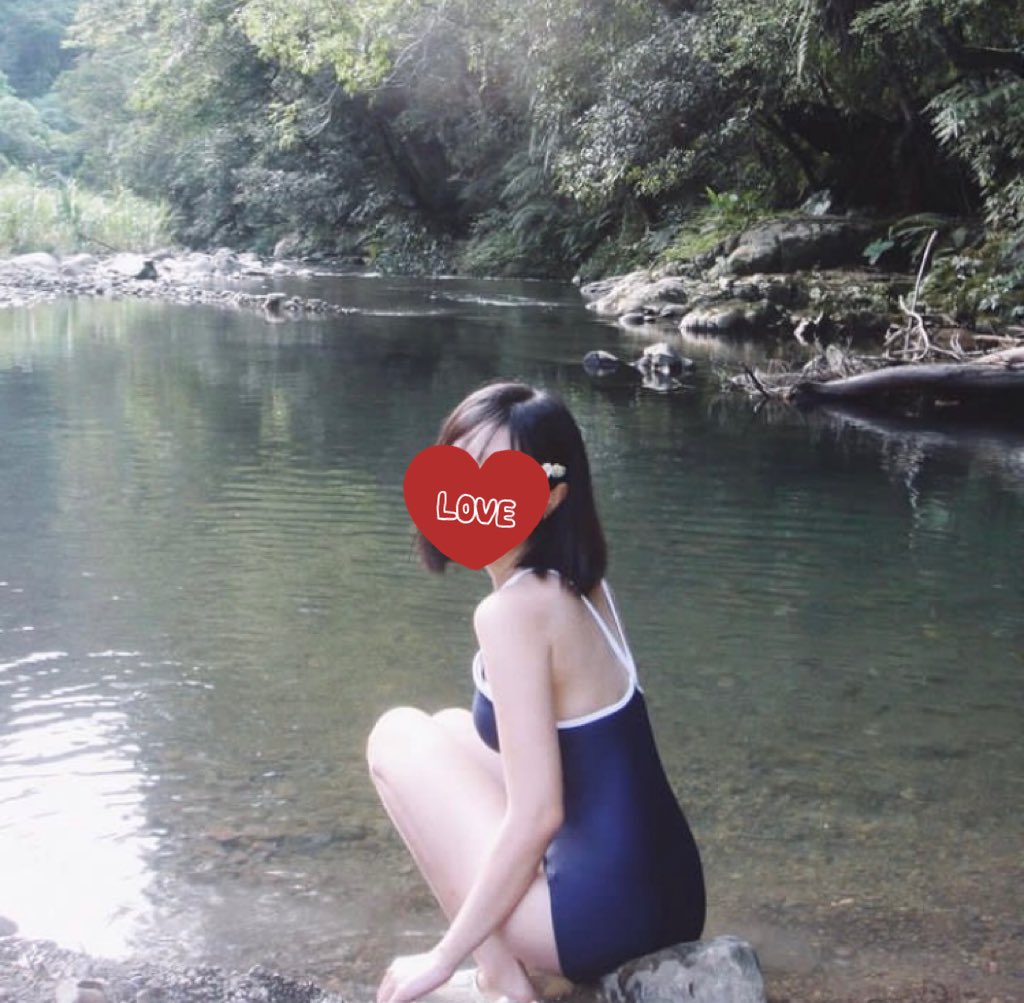 带着心在脸上坐在河边的女人。