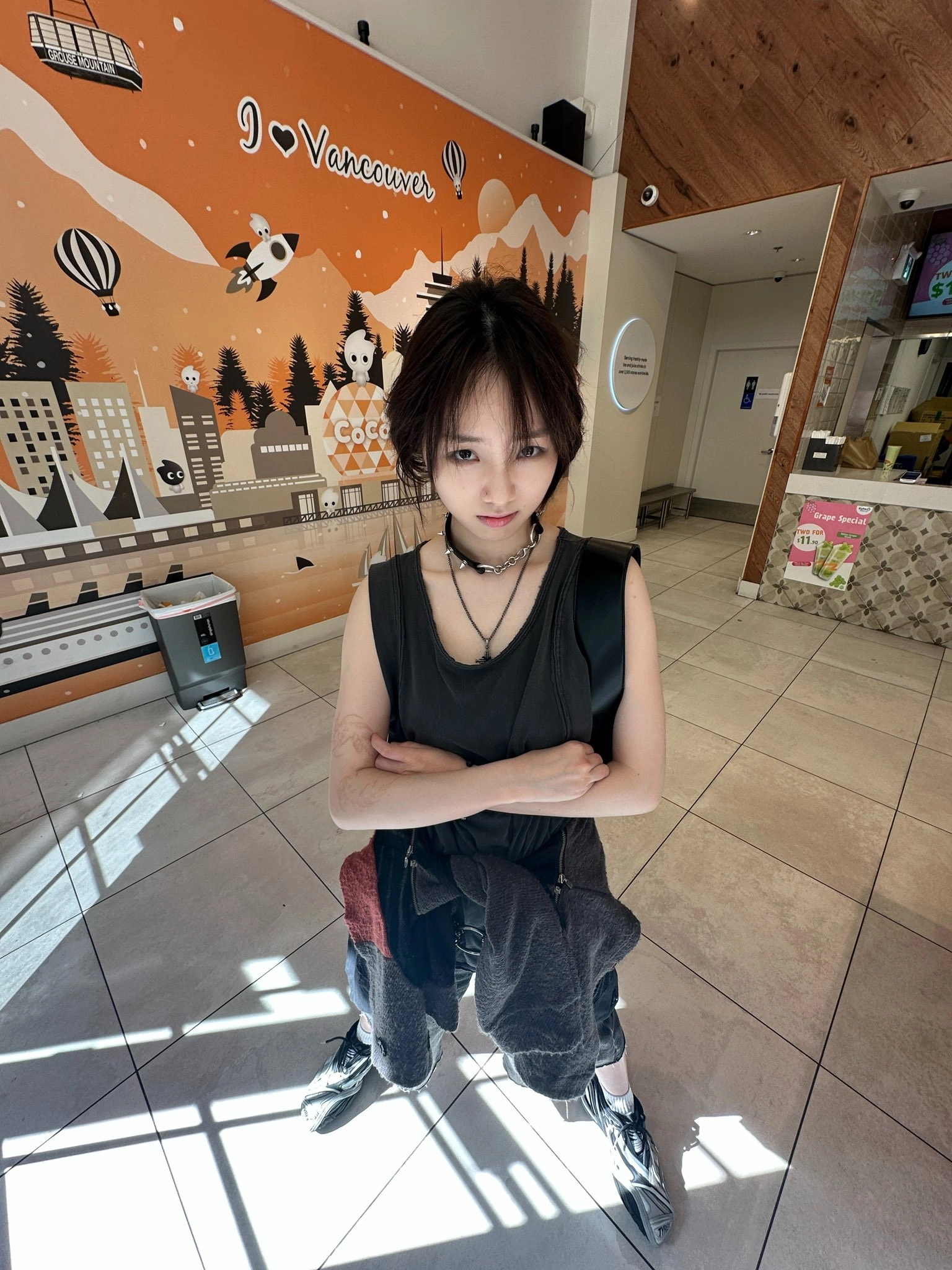 穿着黑色衬衫和项链的女人站在一个房间里。