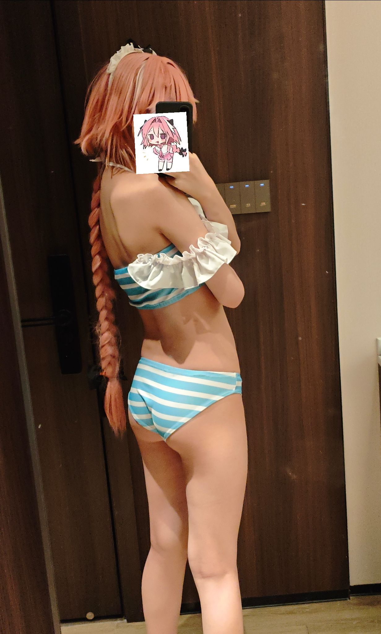 一位穿着蓝色和白色线条的比基尼的女人拍了一张自拍。