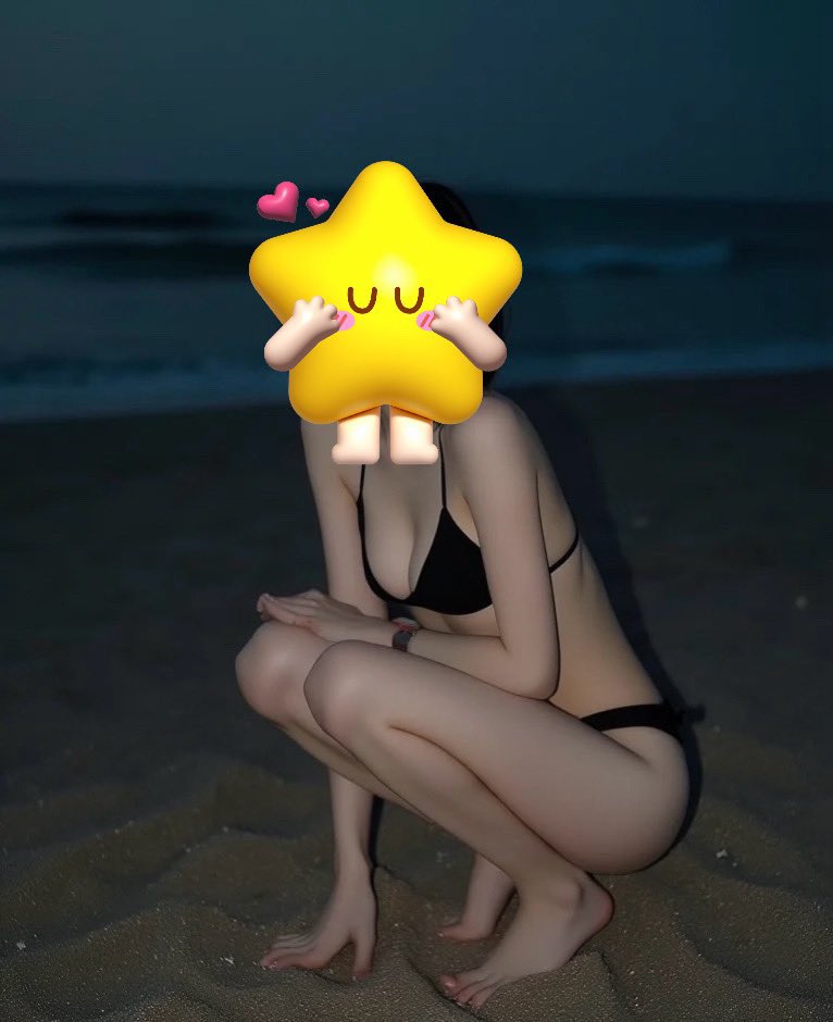 脸上有一颗星星的女人坐在海滩上。