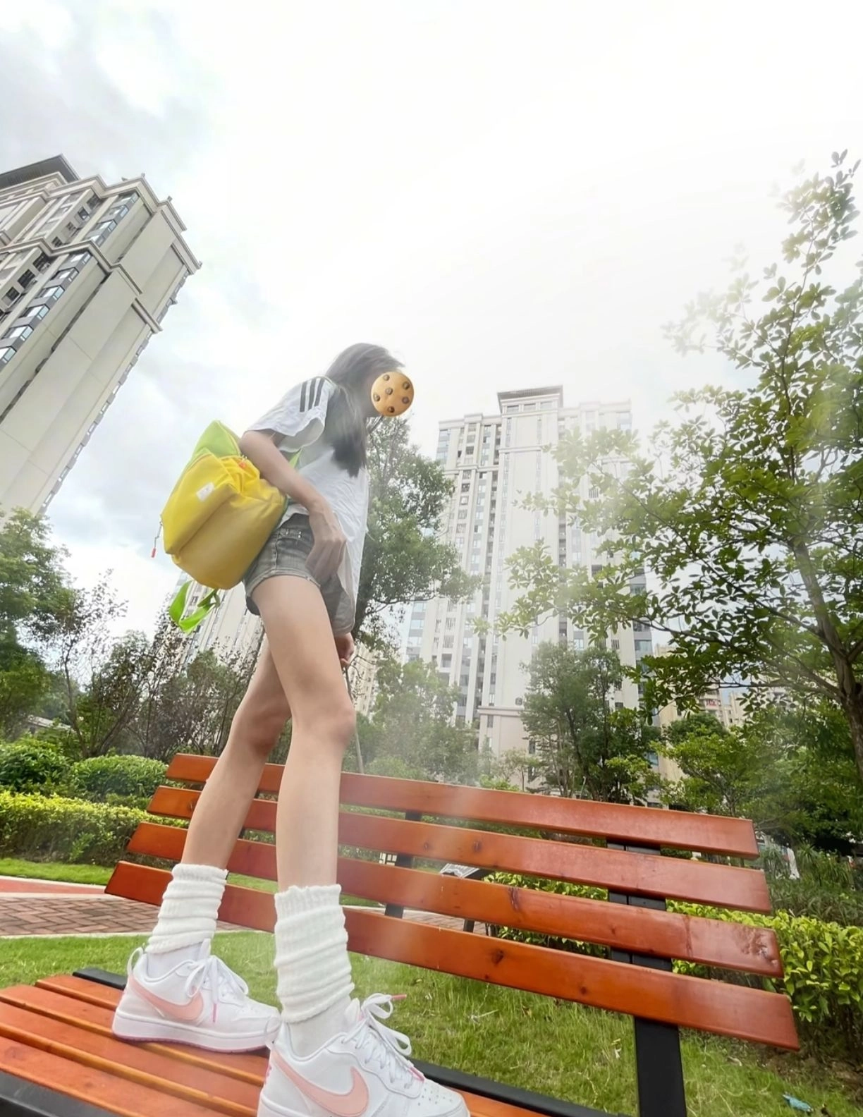 女人肩上有个袋子,脸上有个饼干,走过了一张凳子。