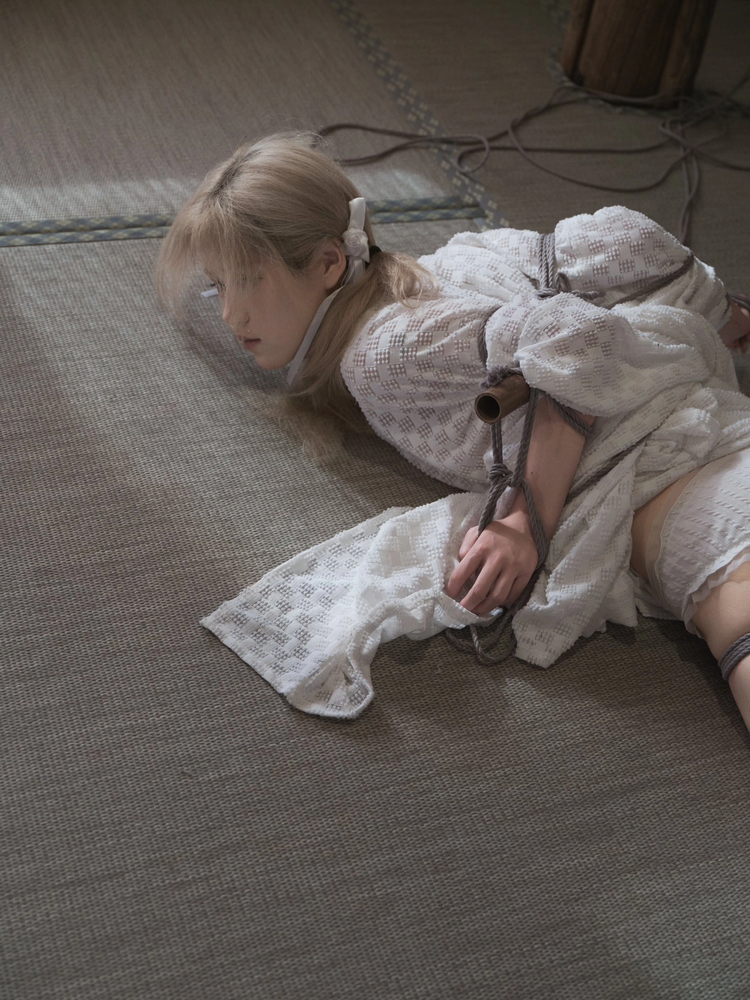 女人被绑起来躺在地板上。