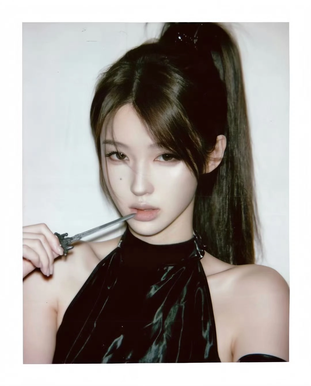 女人戴着一只马尾巴和一件黑色的裙子,拿着一根牙刷。