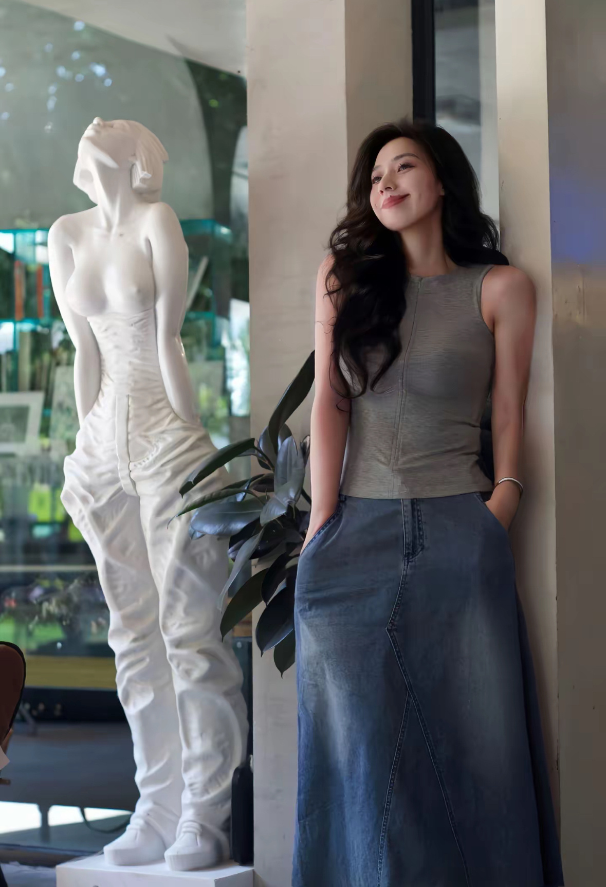 女人站在一个雕像前面。