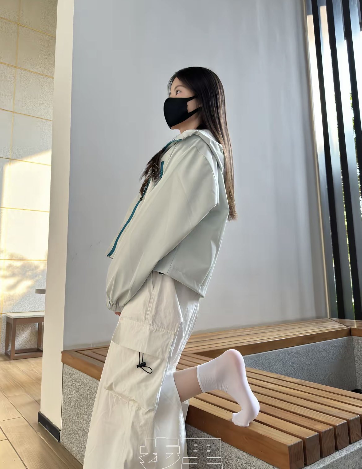 女人戴着面具和一件白色夹克。