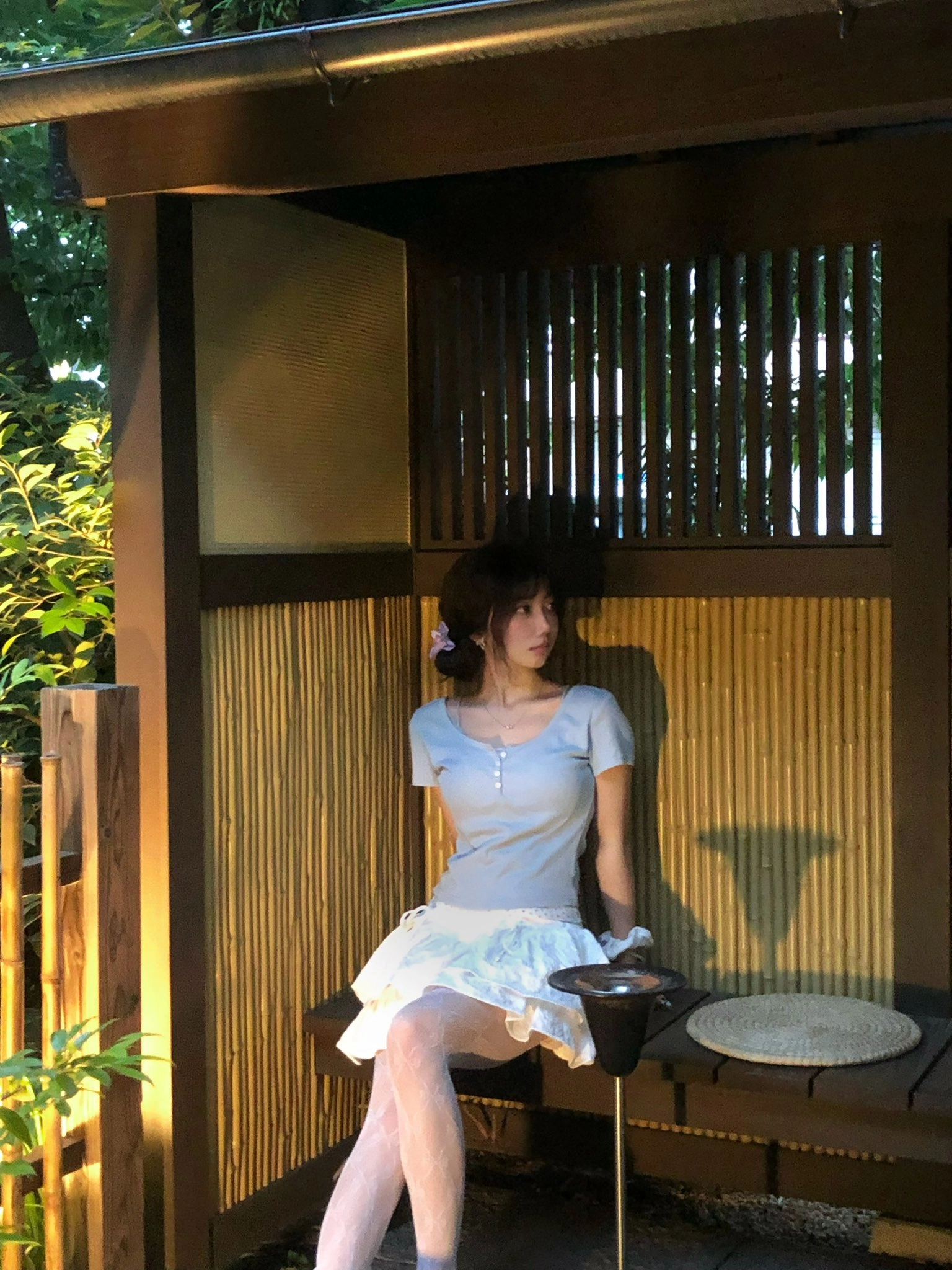 穿着白色衣服的女人坐在一个凳子上。