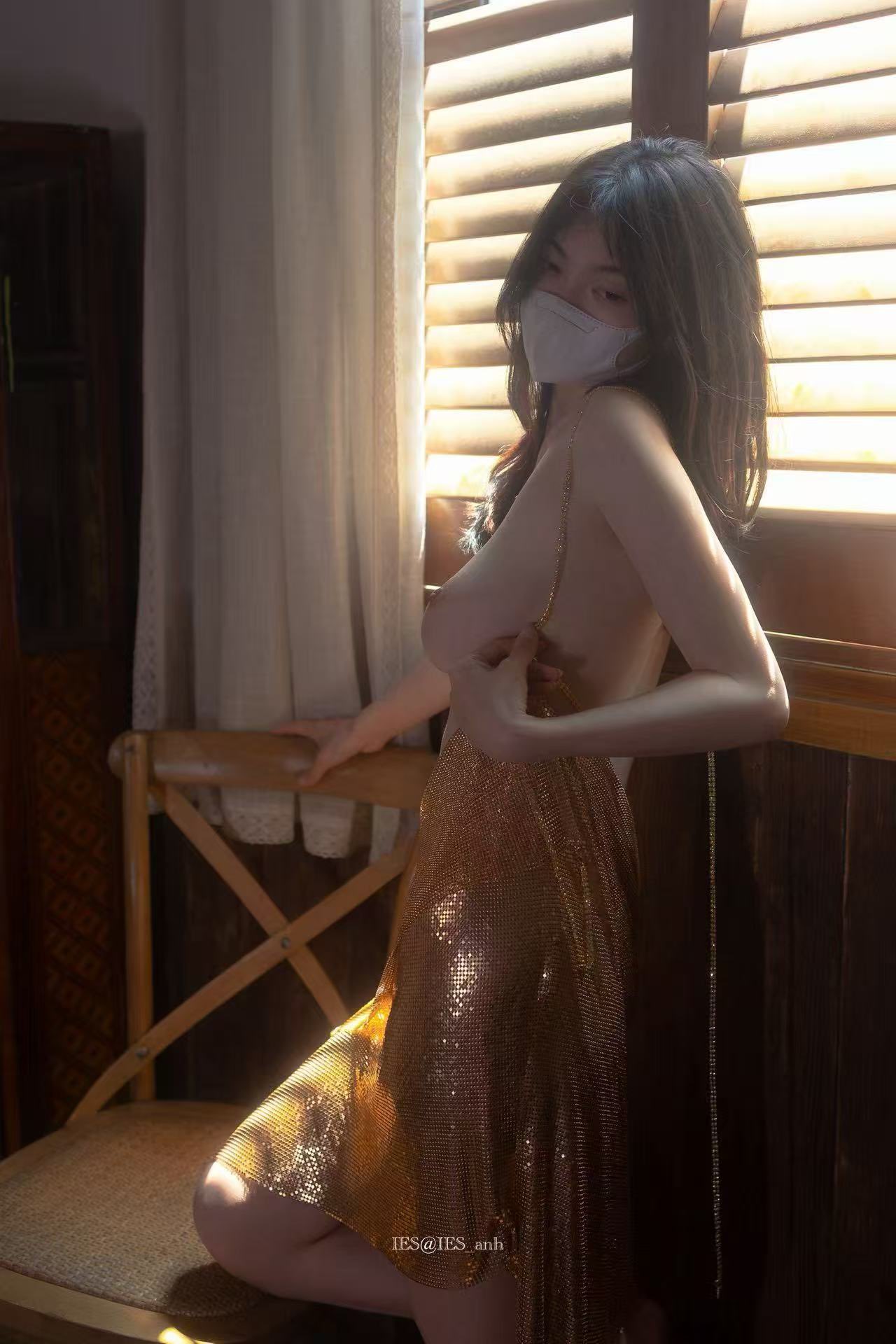 女人戴着面具和一件金色的裙子。