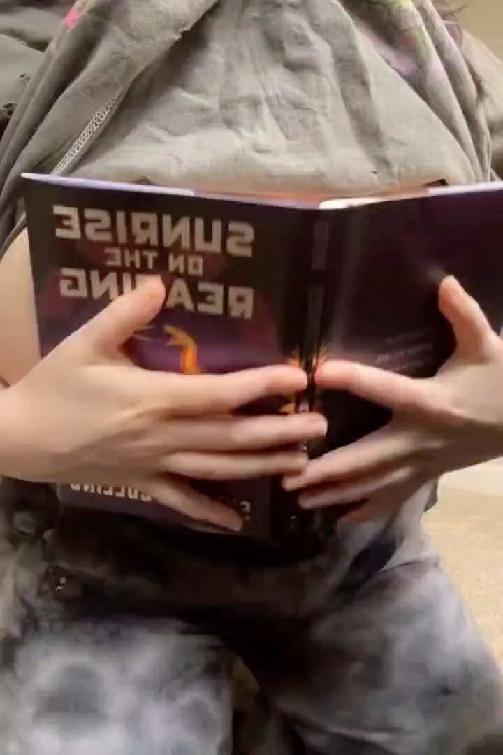 拿着一本书倒下的人。