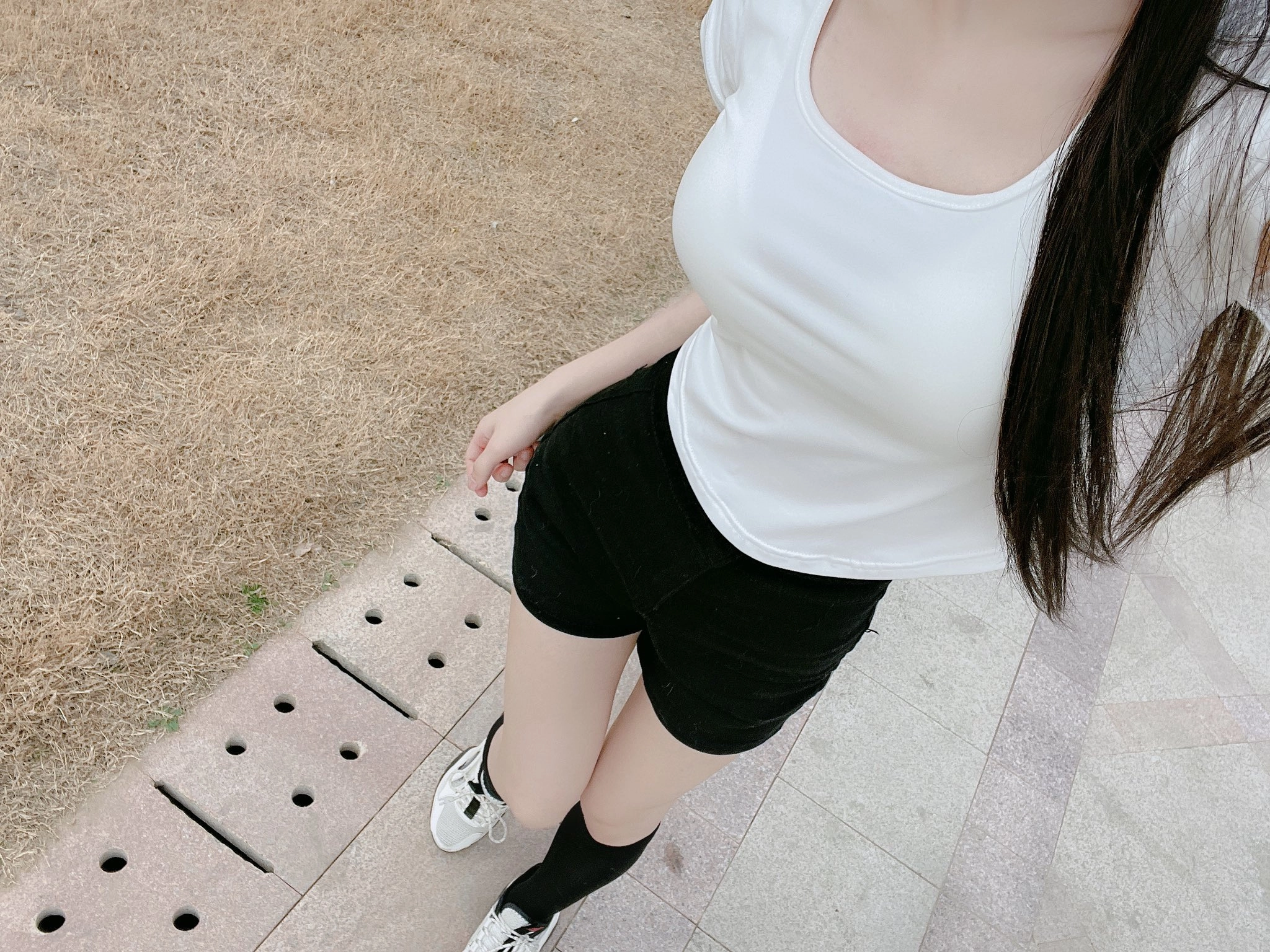 穿黑色短裤和白色衬衫的女人为一张照片。