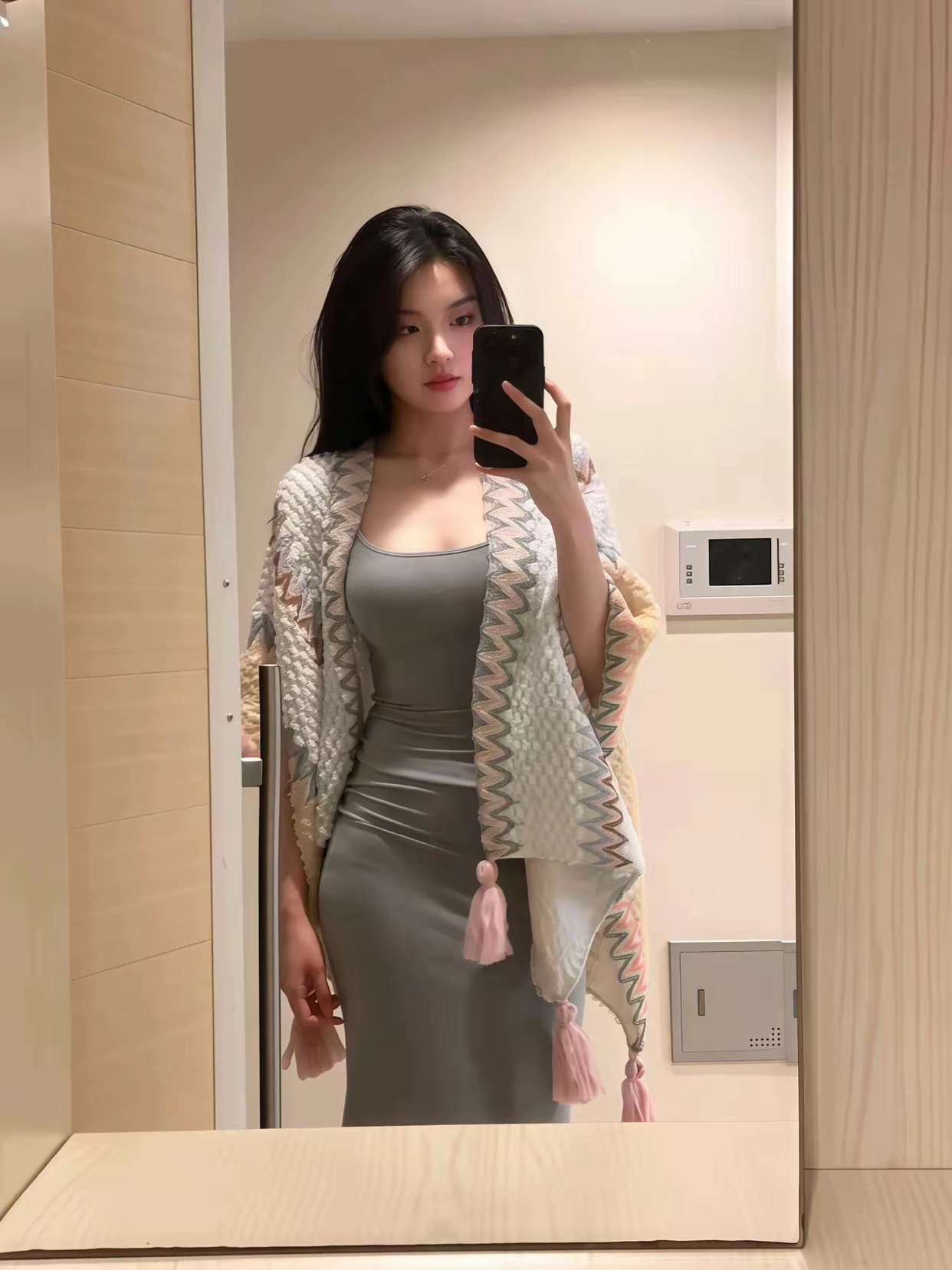 一位穿着灰色裙子和白色衬衫的女人拍了一张自拍。