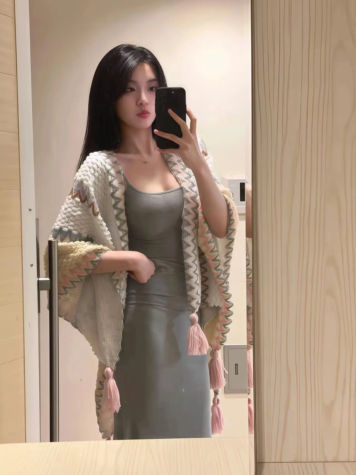 一位穿着灰色裙子和白色衬衫的女人拍了一张自拍。