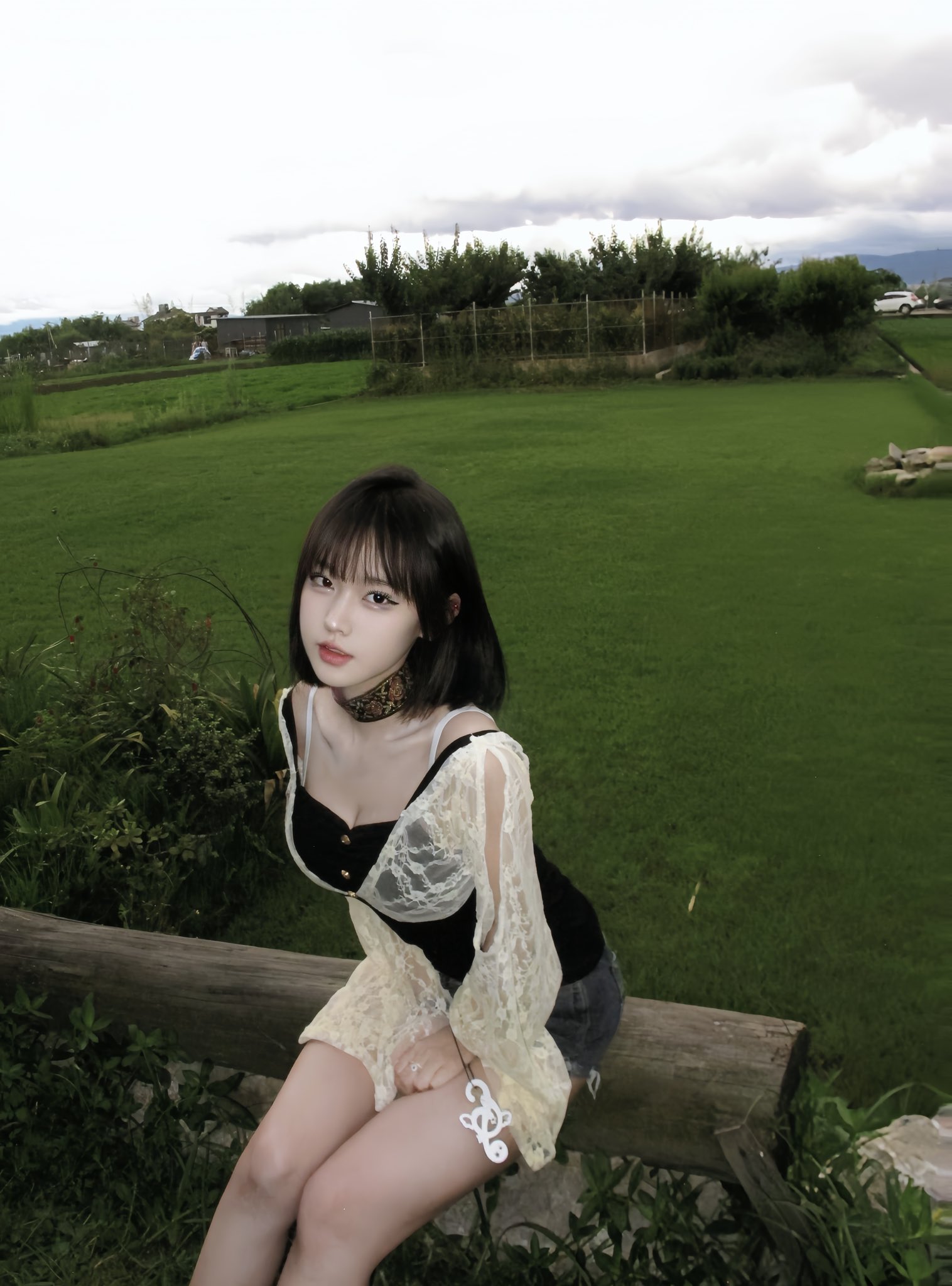 穿着黑色顶部和白色短裤的女人坐在一个围栏上。