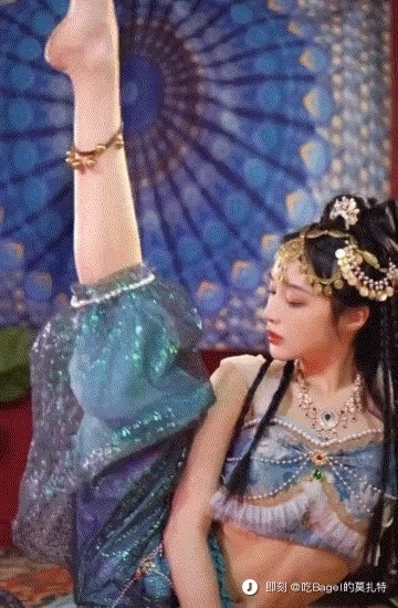 一位穿着蓝色裙子和金头衣的女人正在为一张照片而立场。