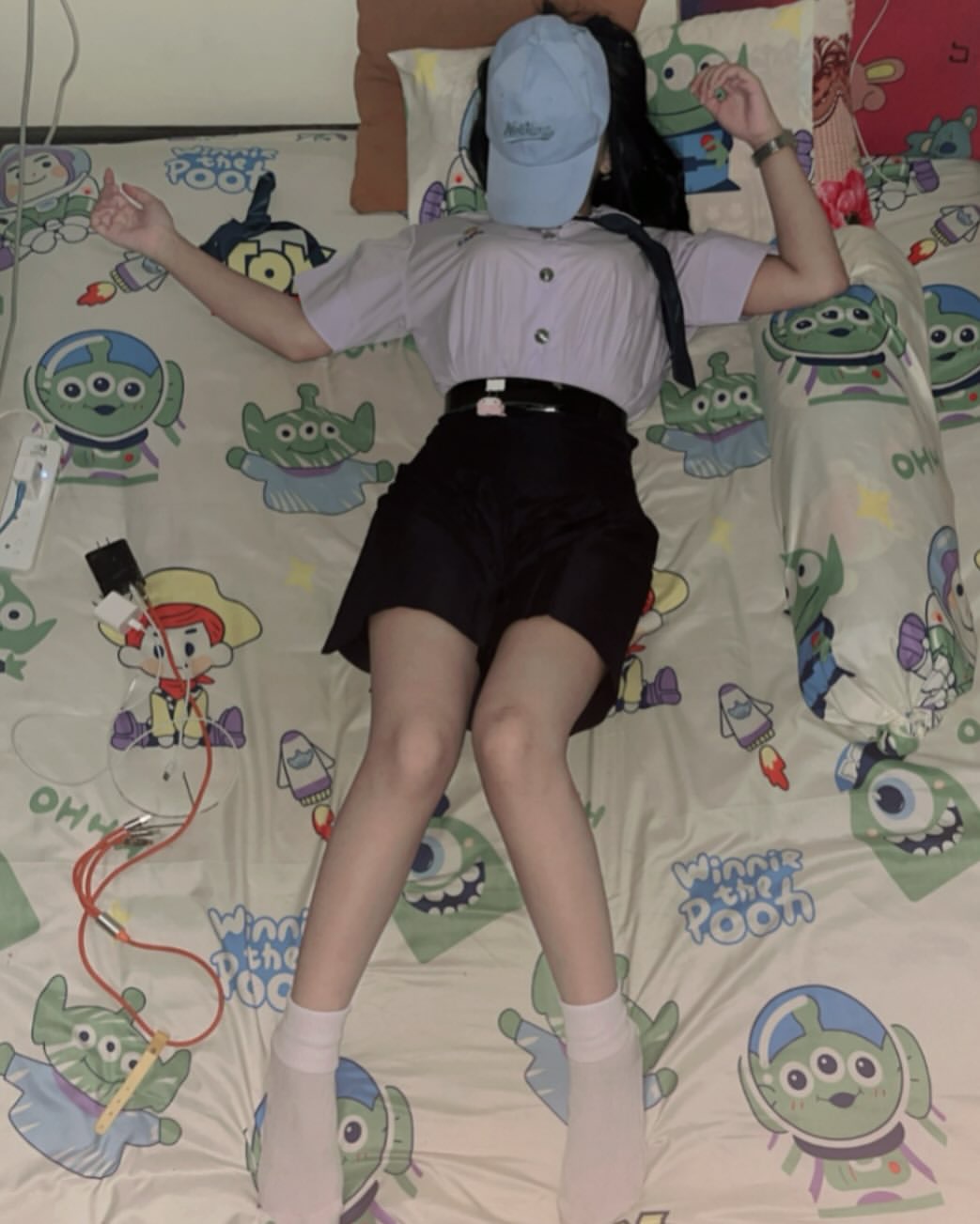 穿着马尾巴的女孩躺在一张玩具故事舒适器的床上。