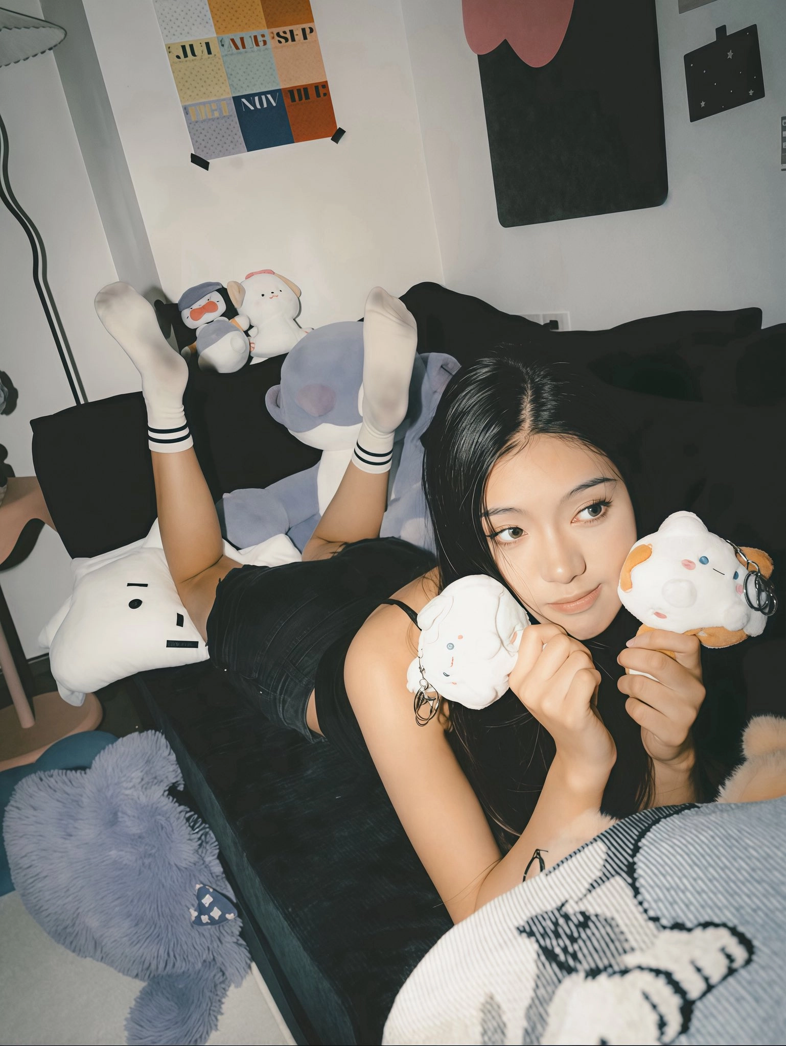 女孩躺在一张充满动物的床上,拿着一个Hello Kitty玩具。