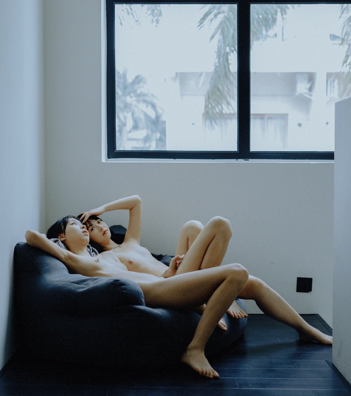 两个裸体的女人坐在沙发上。