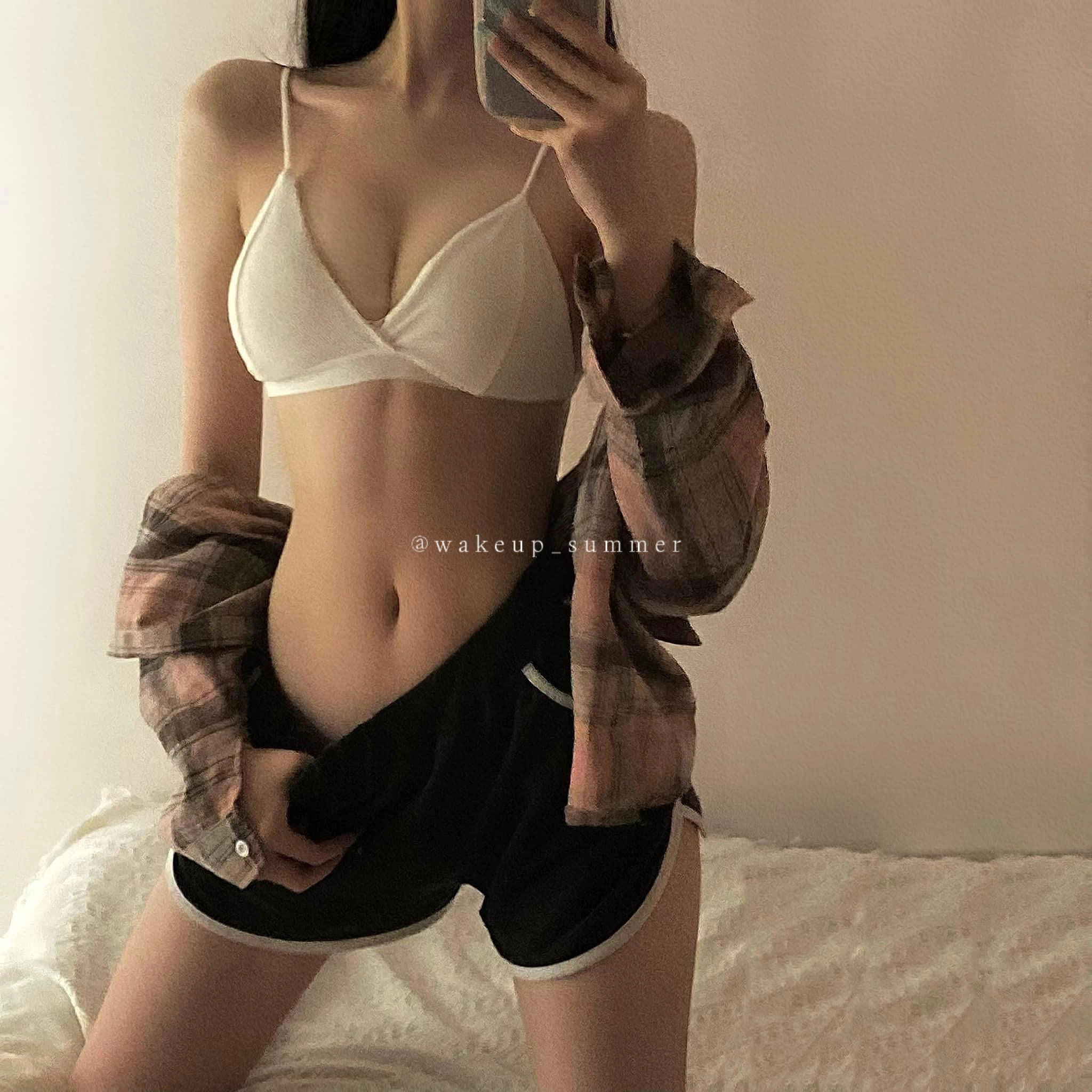 一位穿着白色衬衫和黑色短裤的女人拍了一张自拍。