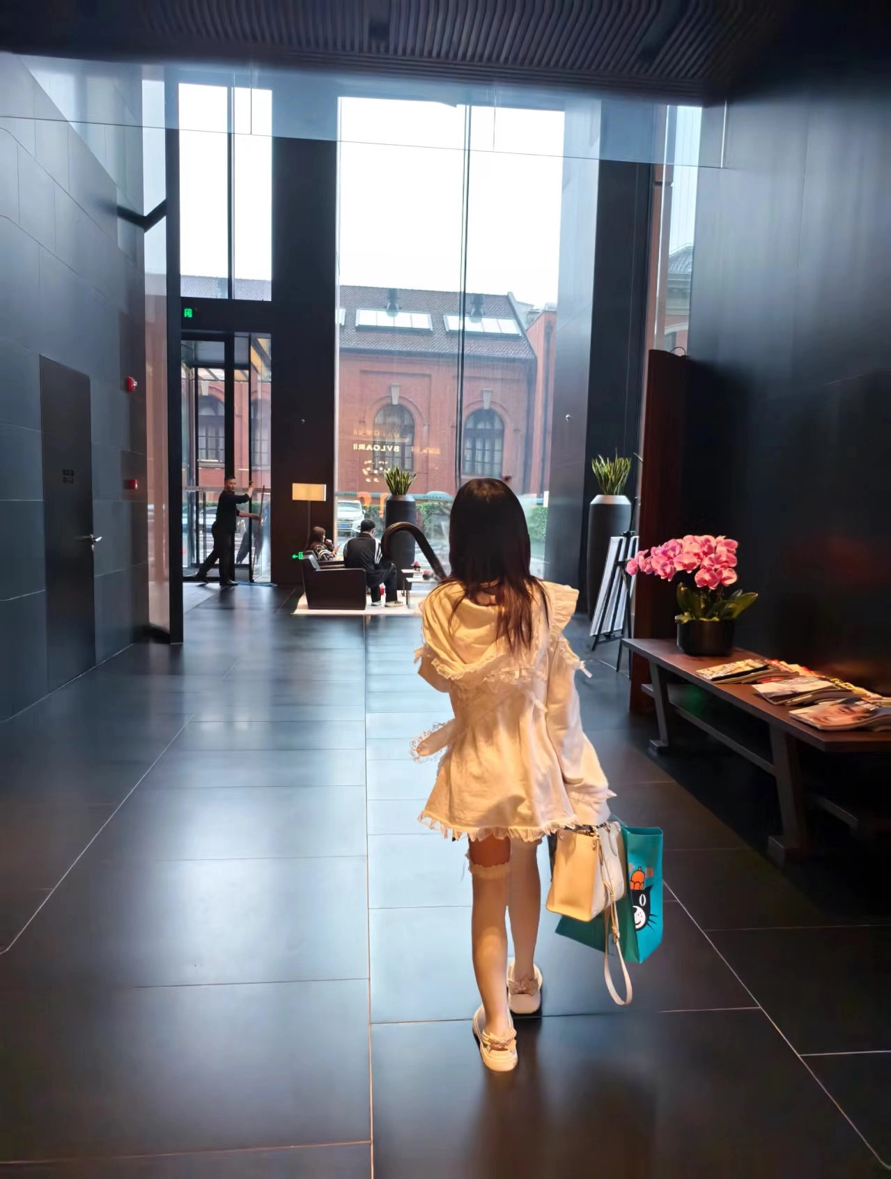 一位穿着白色衣服的女人走在走廊上。