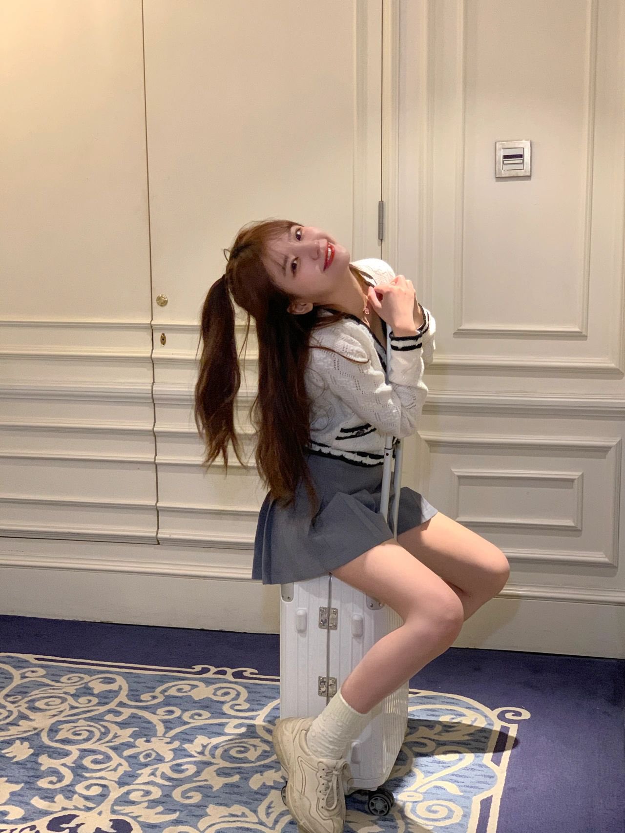 带着一只马尾巴和一件白色衬衫的女孩在椅子上姿势。