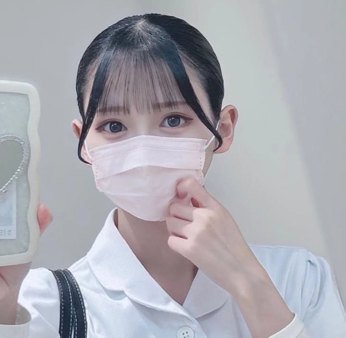 戴着粉红色面具的女人抱着一个心脏形状的物品。