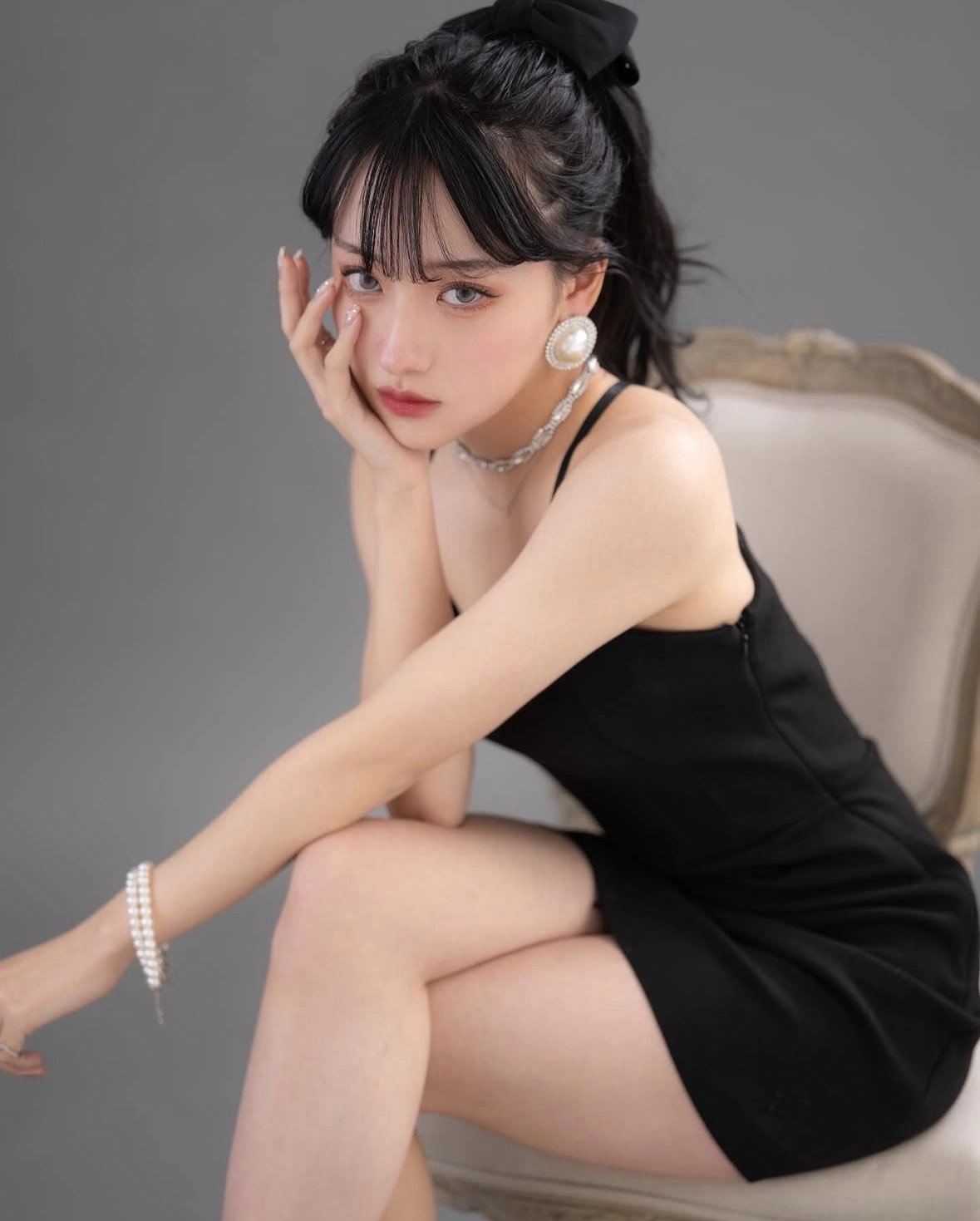 穿着黑色裙子和珍珠耳环的女人。