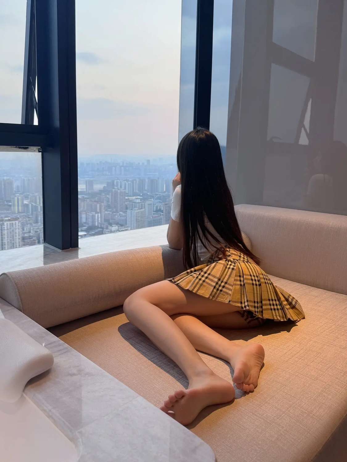 长头发和一个黄色的裙的女人坐在沙发上。