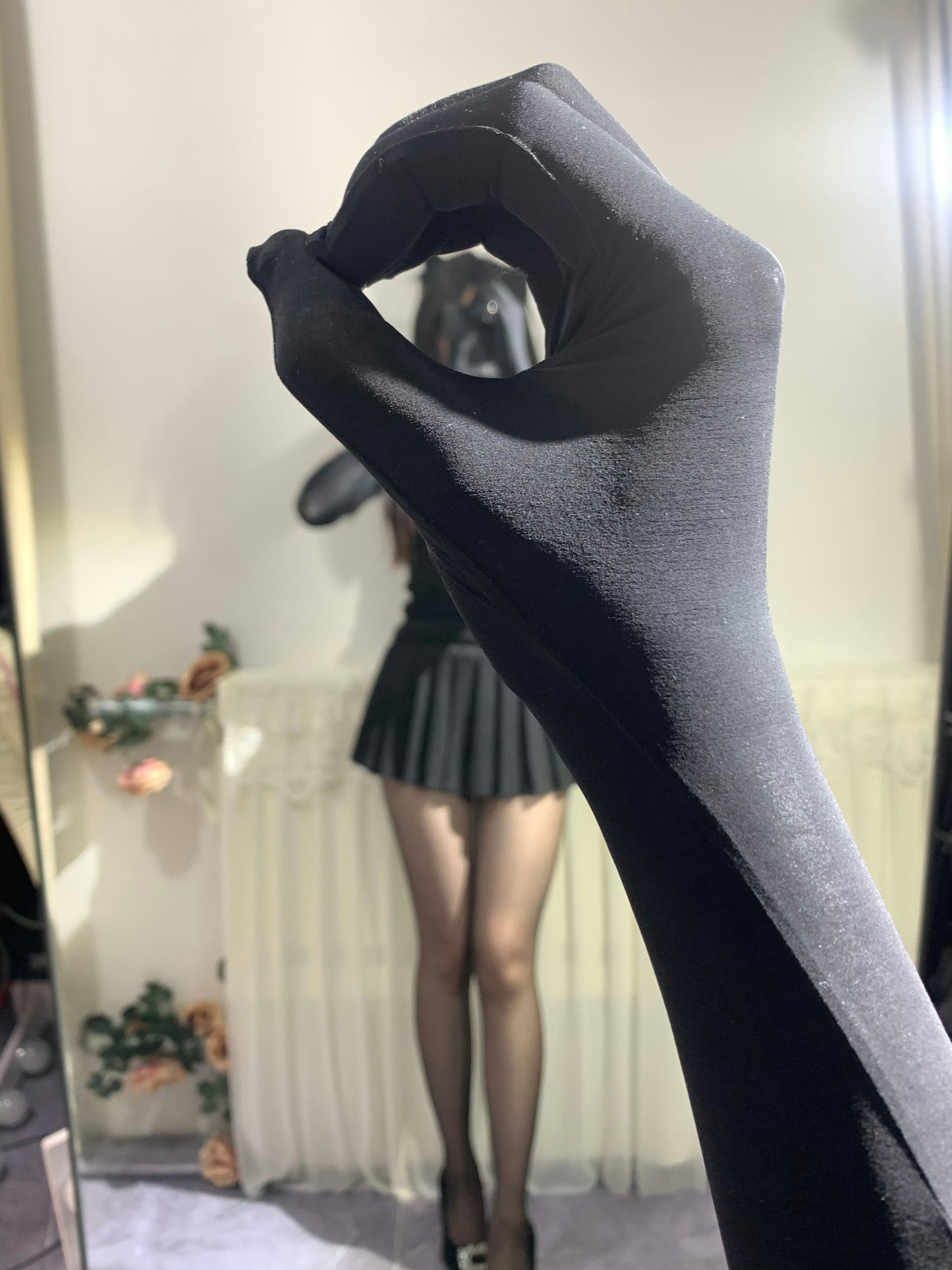 一只手拿着一把黑色的手套,一根拇指抬起来。