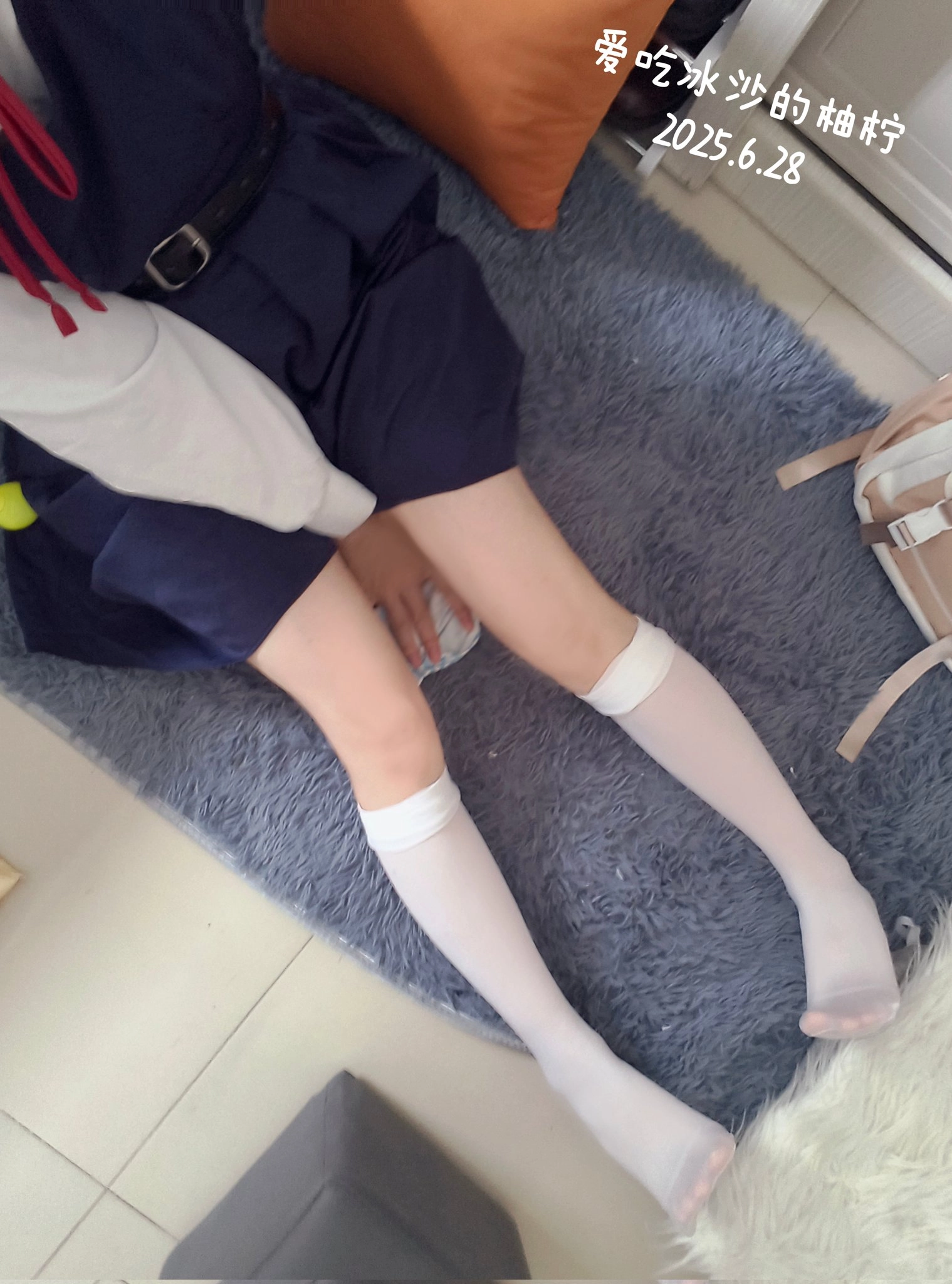 穿着蓝色裙子的女孩坐在地毯上。