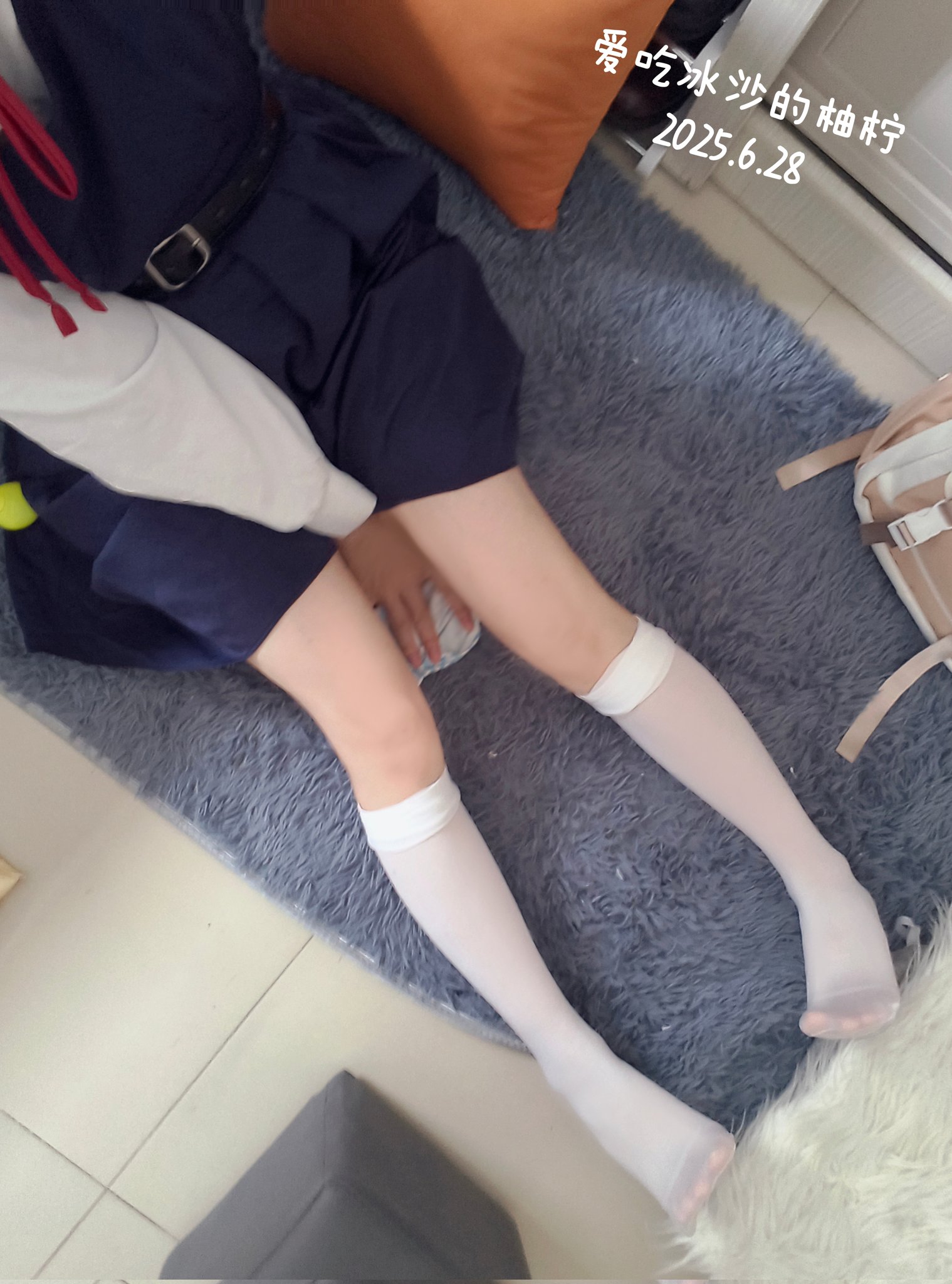 穿着蓝色裙子的女孩坐在地毯上。