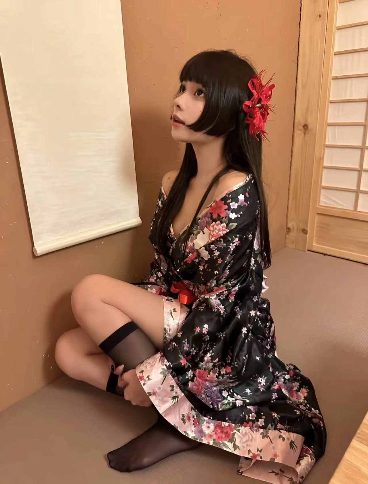 女人穿着黑色吉莫诺,头发里有一朵红色的花。